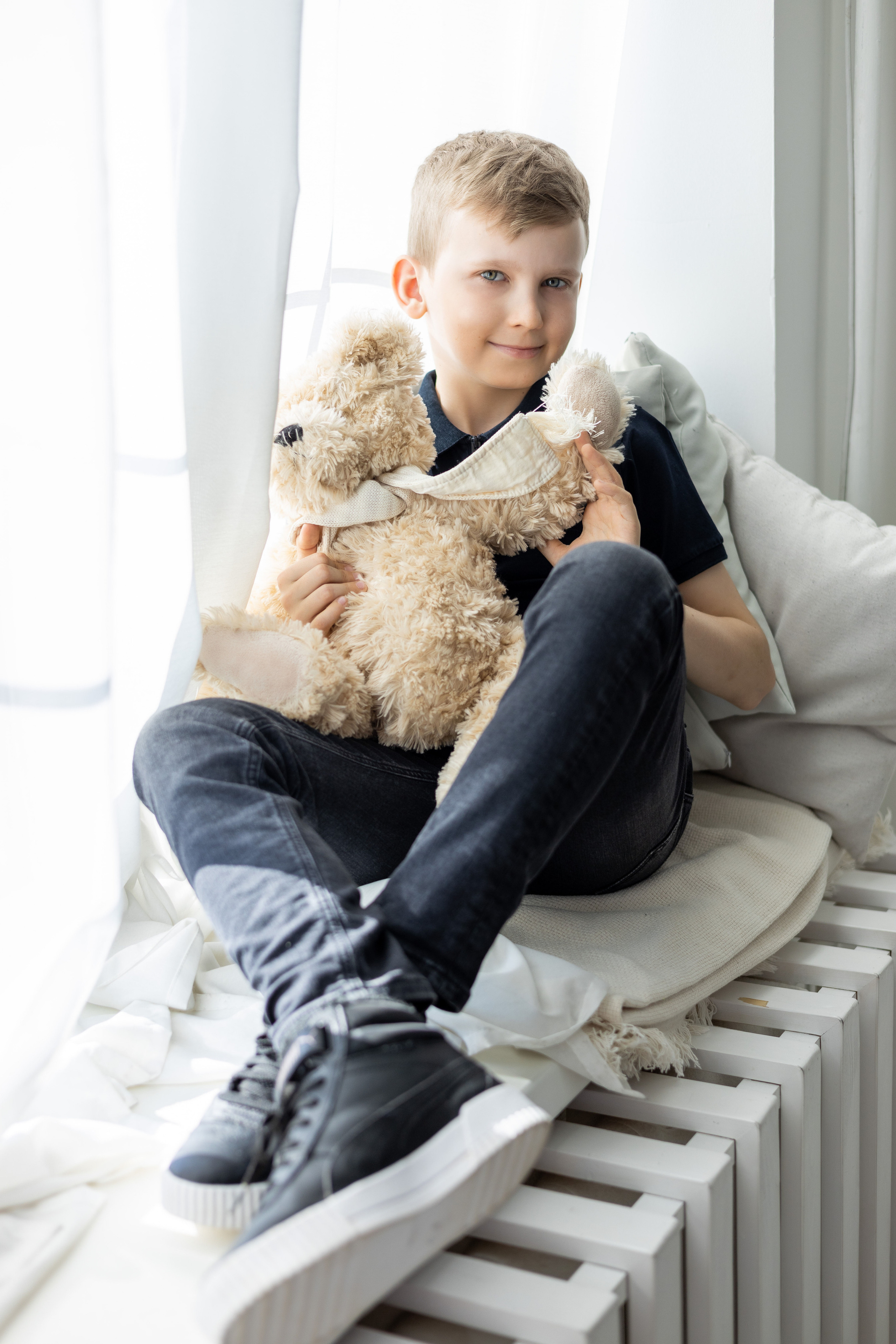 Школьник из Коломны позирует с медвежонком для школьной фотокниги.