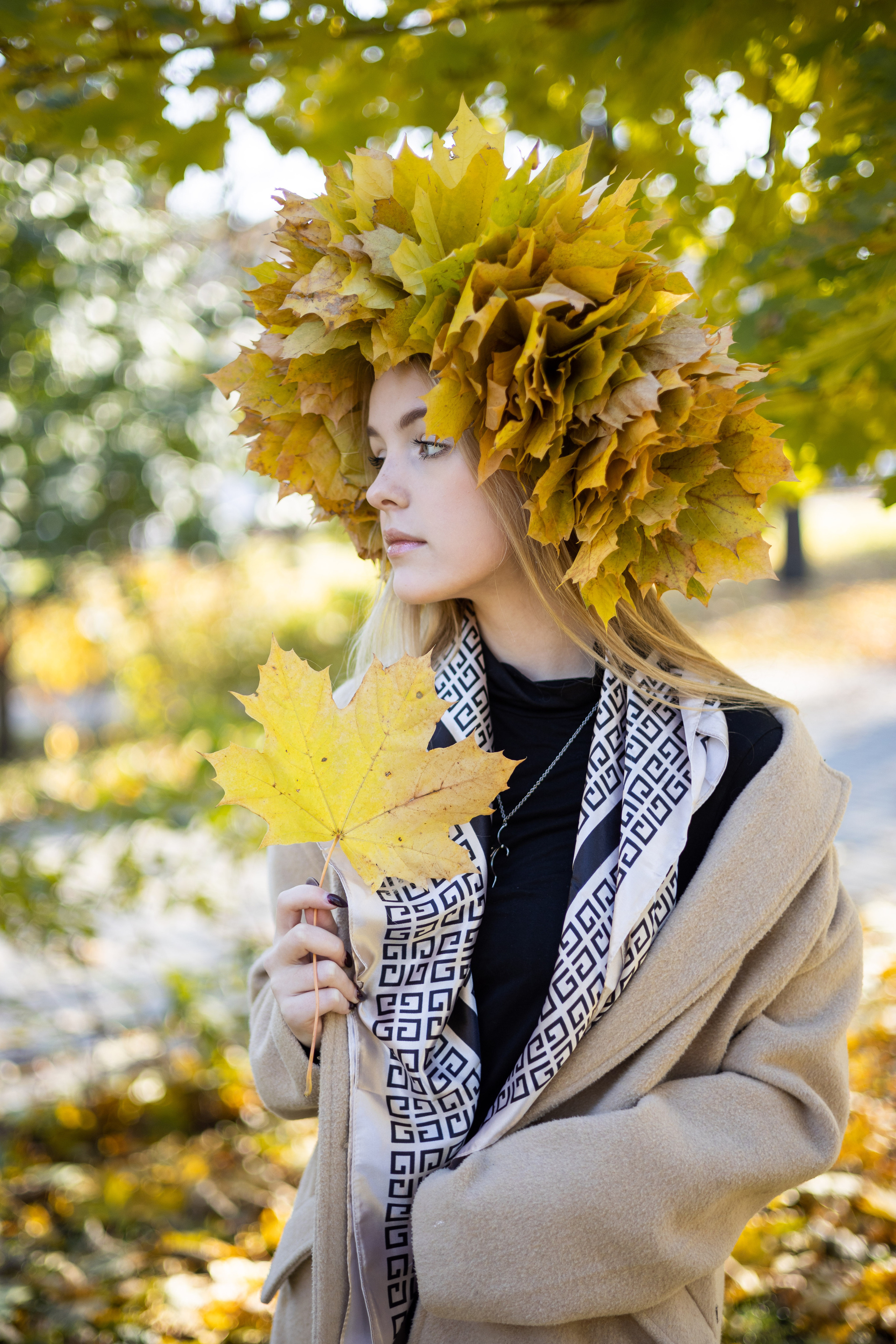 Школьница в венке из кленовых листьев, с кленовым листом в руке.