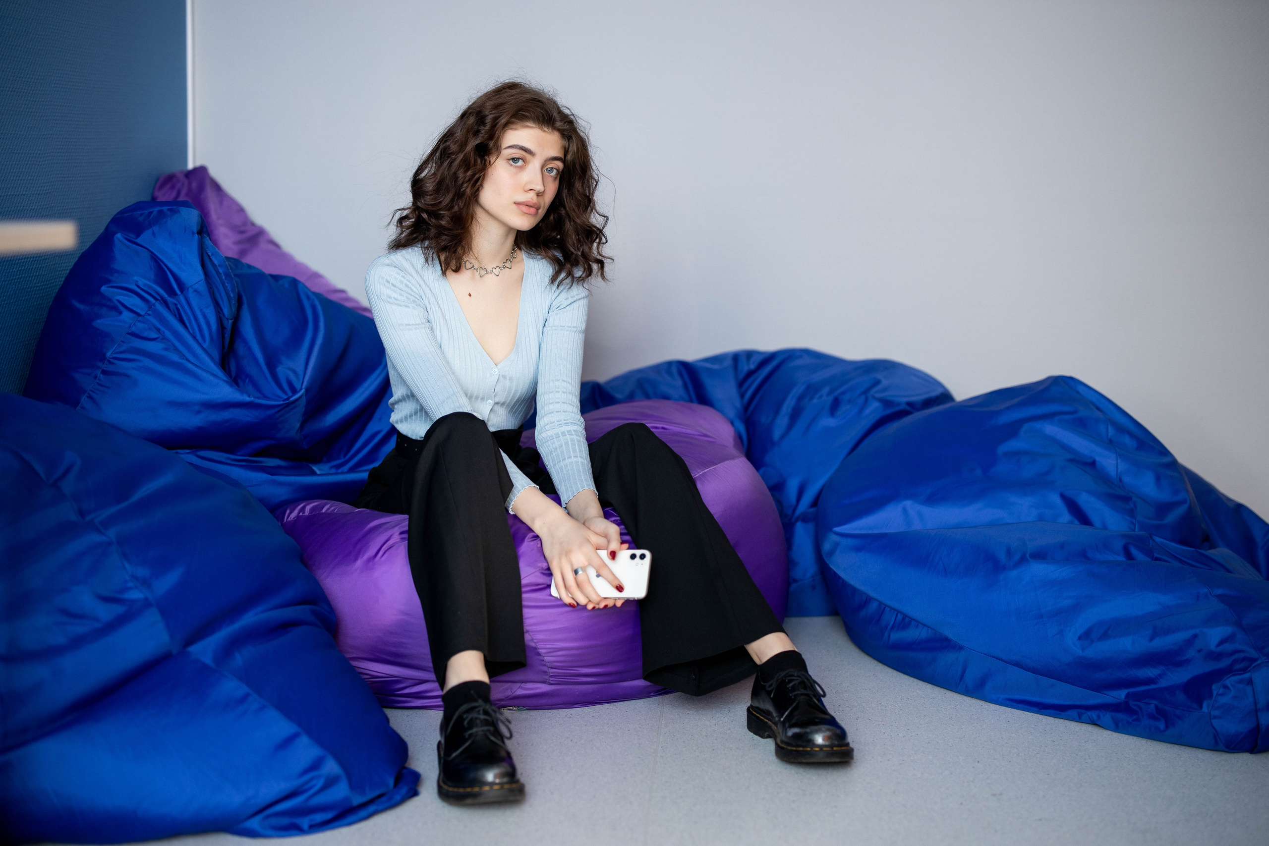 Ученица 11-го класса сидит на пуфиках.