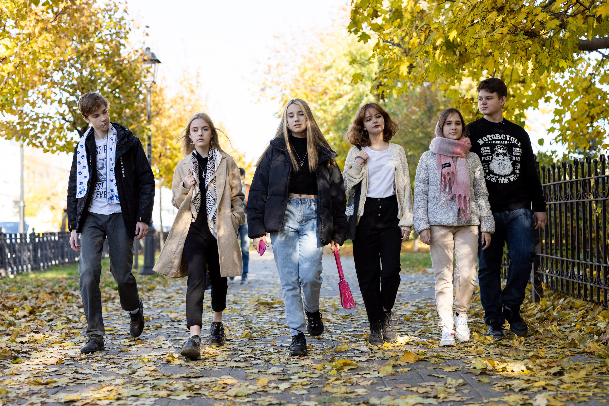 Группа школьников идёт по дорожке в городском парке.