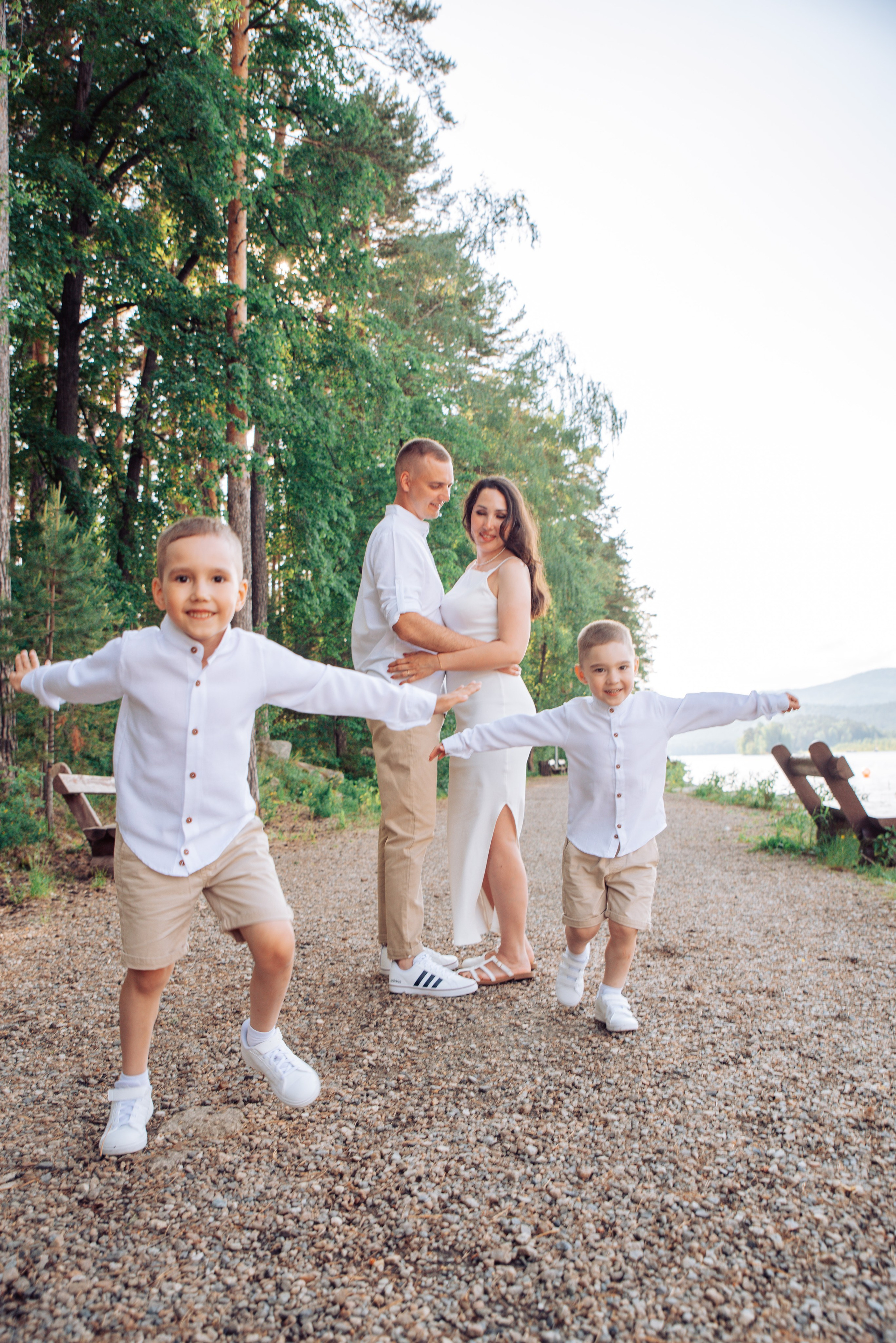 Семейная прогулка летом на берегу озера по пляжу