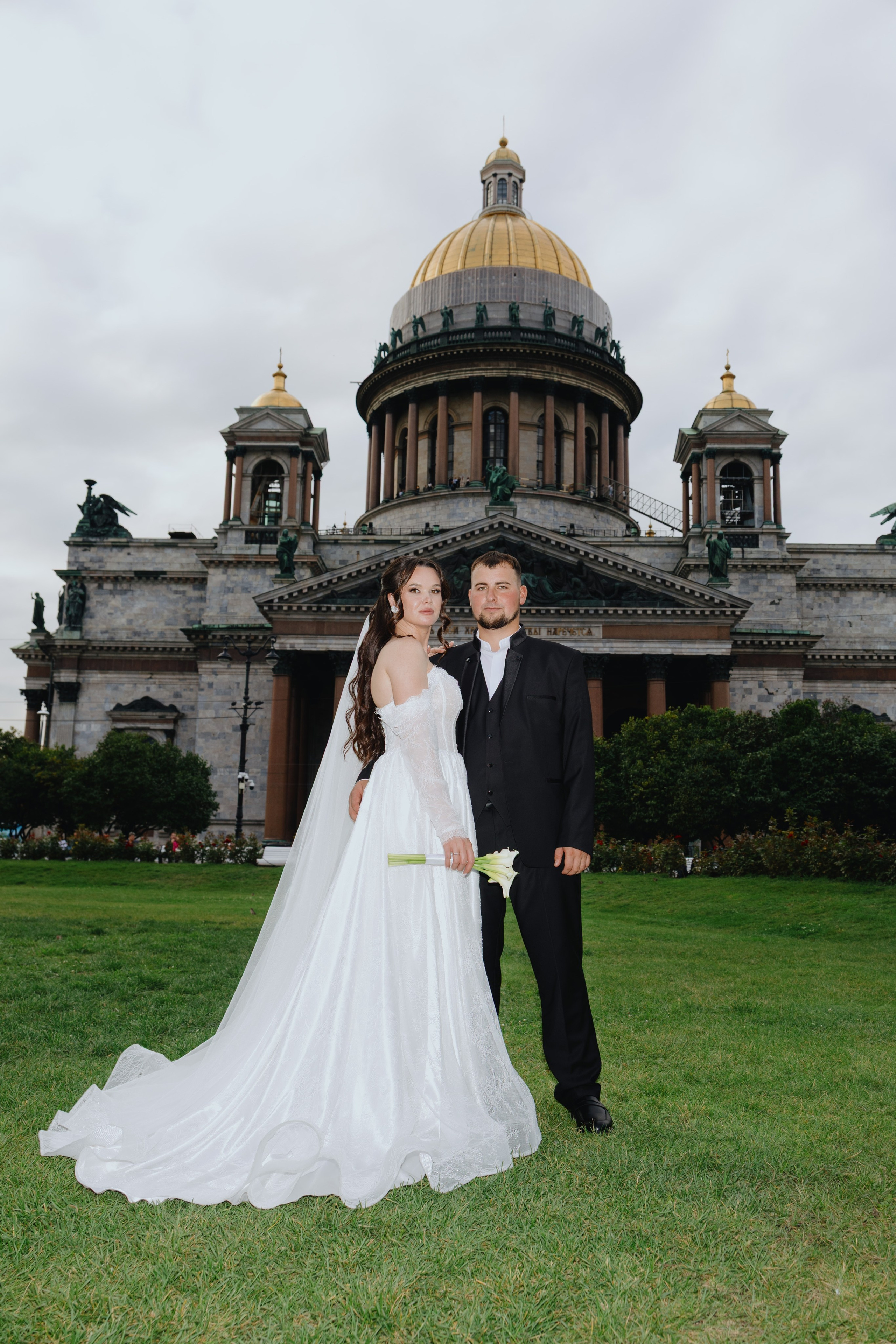 Классическая свадебная фотосессия у Исаакиевского собора в Санкт-Петербурге. Невеста в пышном платье и жених на фоне архитектурной доминанты города.