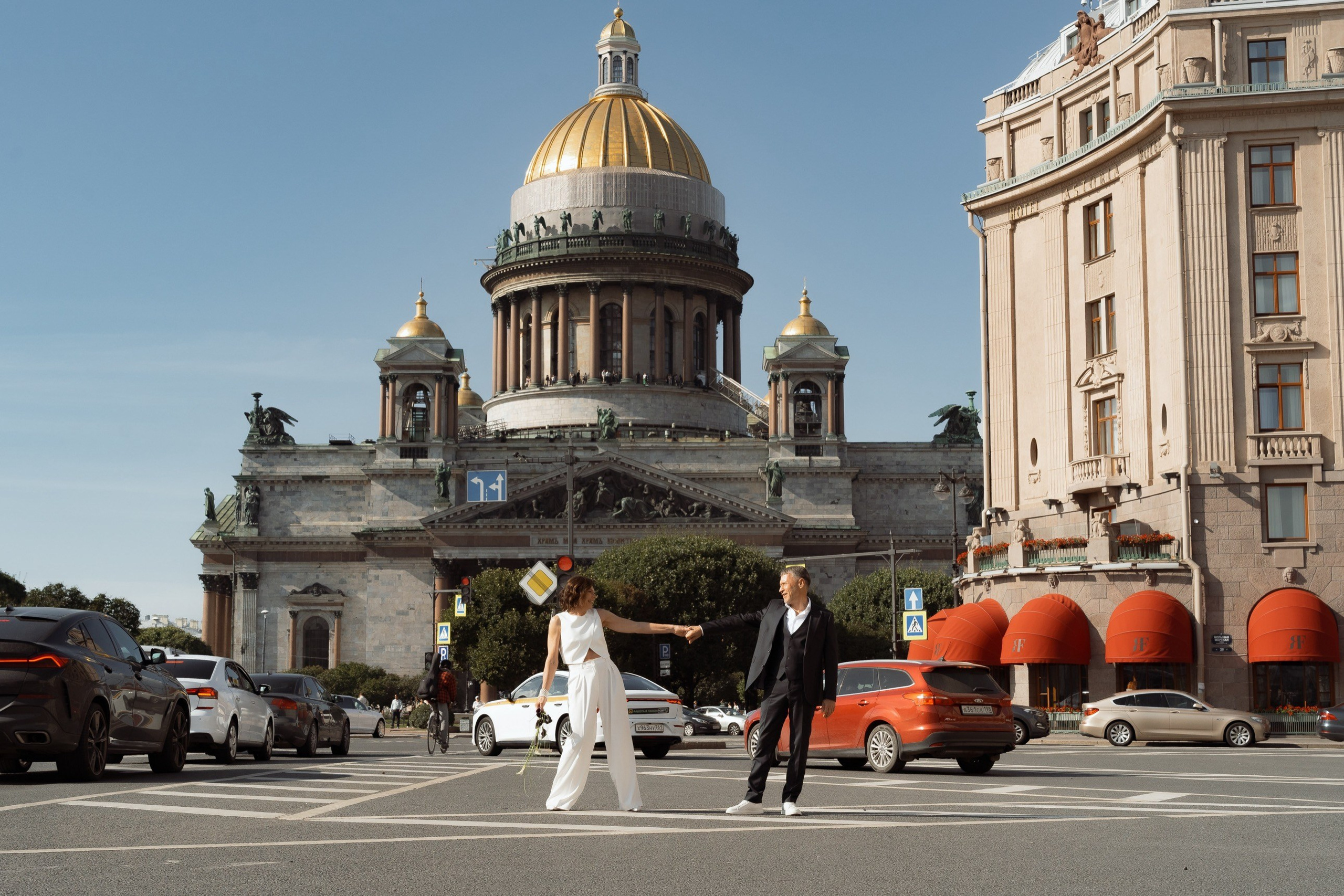 Пара пересекает Исаакиевскую площадь на фоне купола собора, камерная свадьба в Санкт-Петербурге