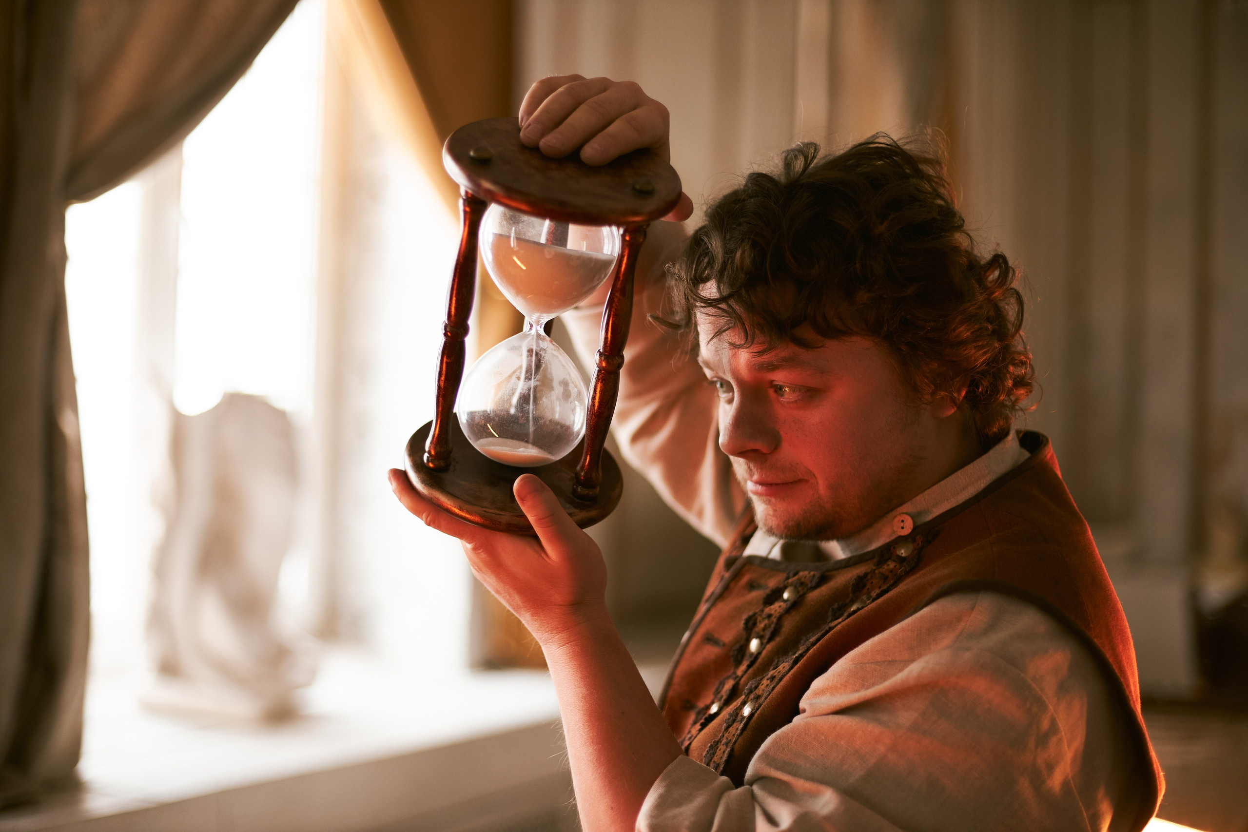  Сергей Друзьяк держит в руках огромные песочные часы в деревянной оправе