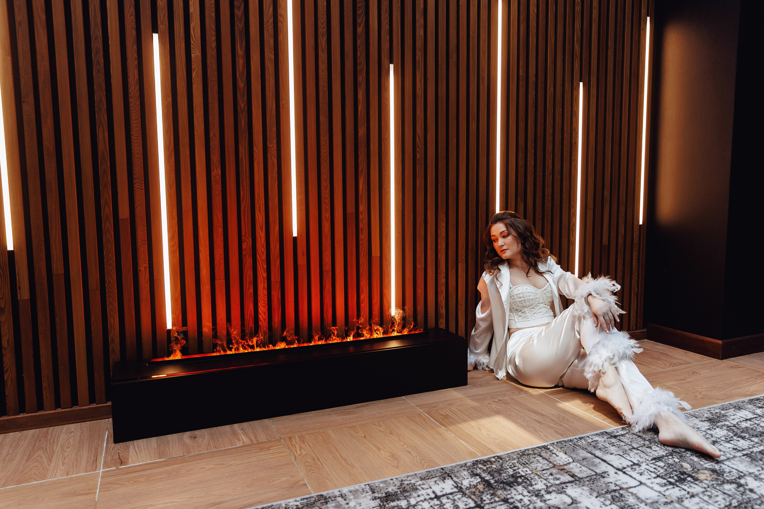 Невеста в красивом пеньюаре сидит на фотосессии утра невесты