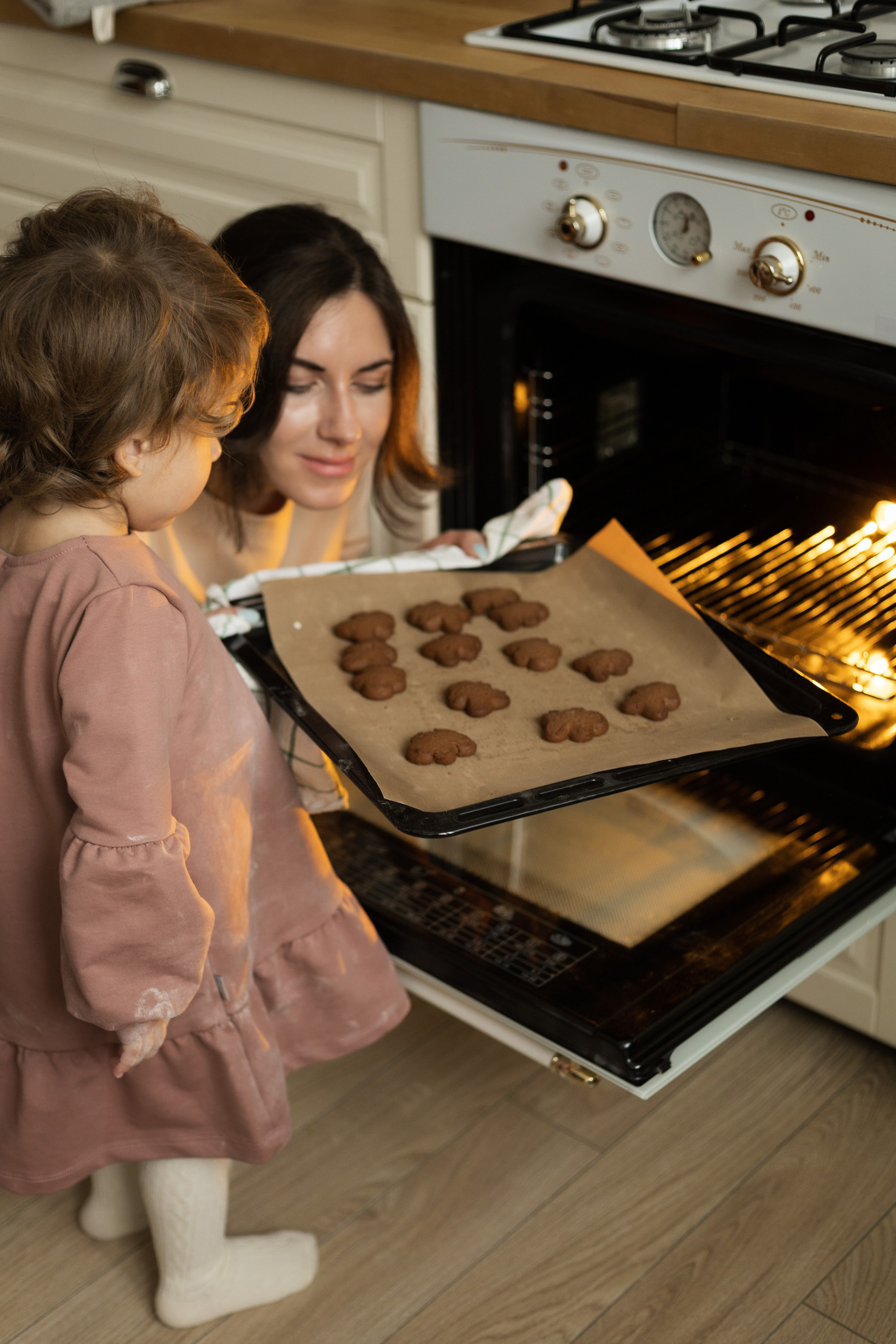 Важный этап выпечки: хозяйка аккуратно помещает заготовки в печь, проявляя терпение и внимательность