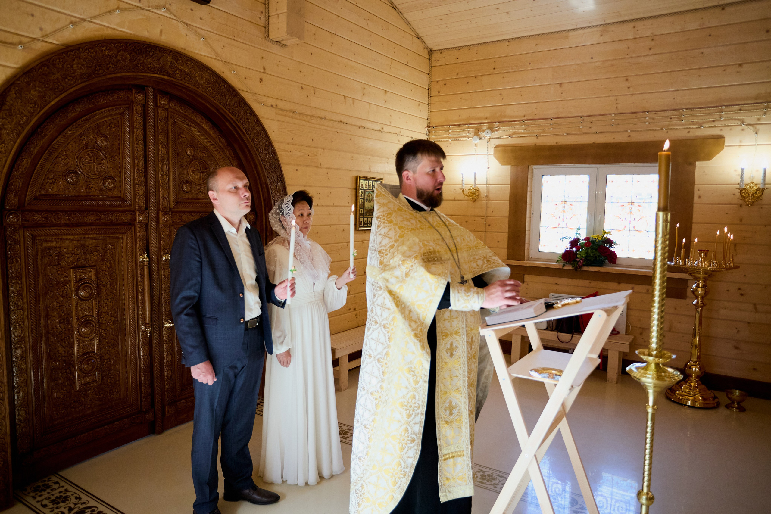 батюшка читает молитву в церкви перед венчанием