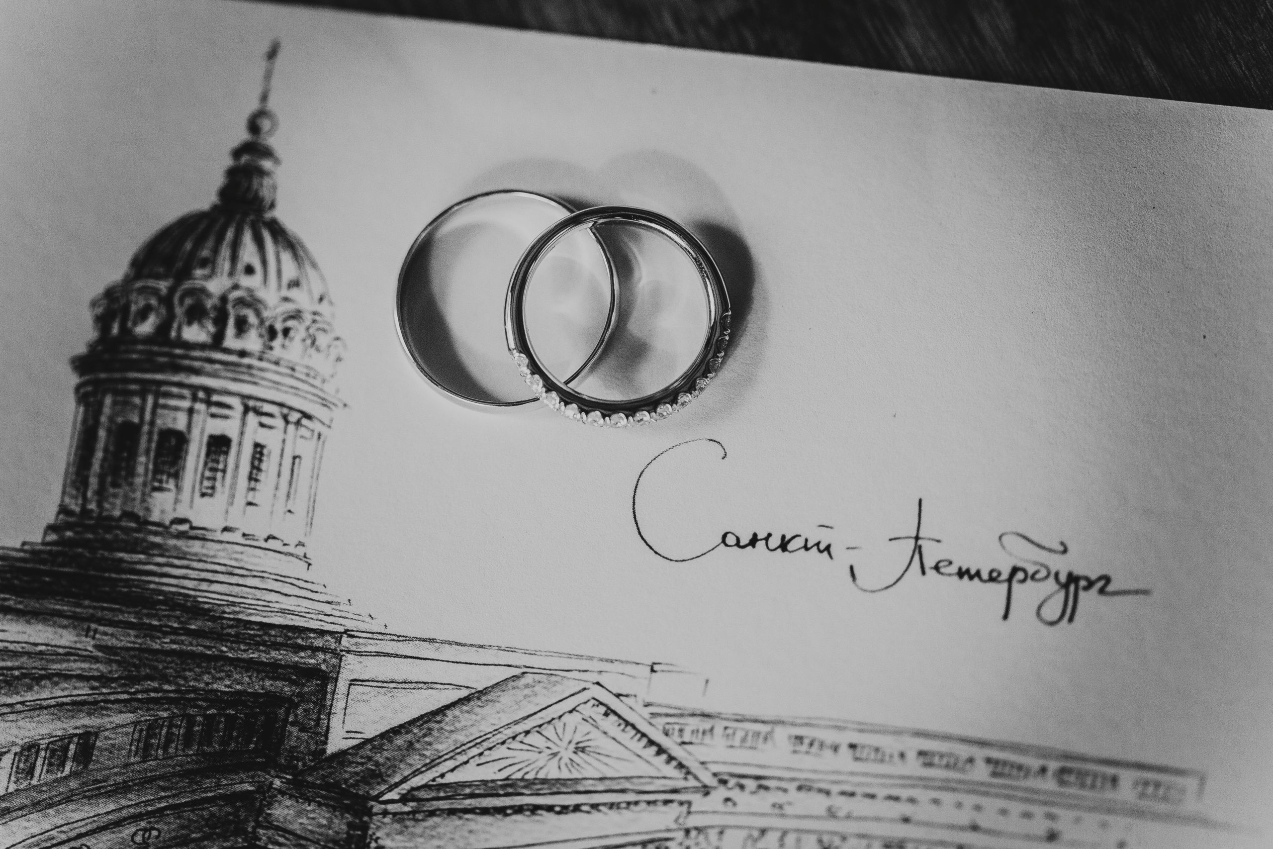 обручальные кольца лежат на чёрно-белой открытке Санкт-Петербург