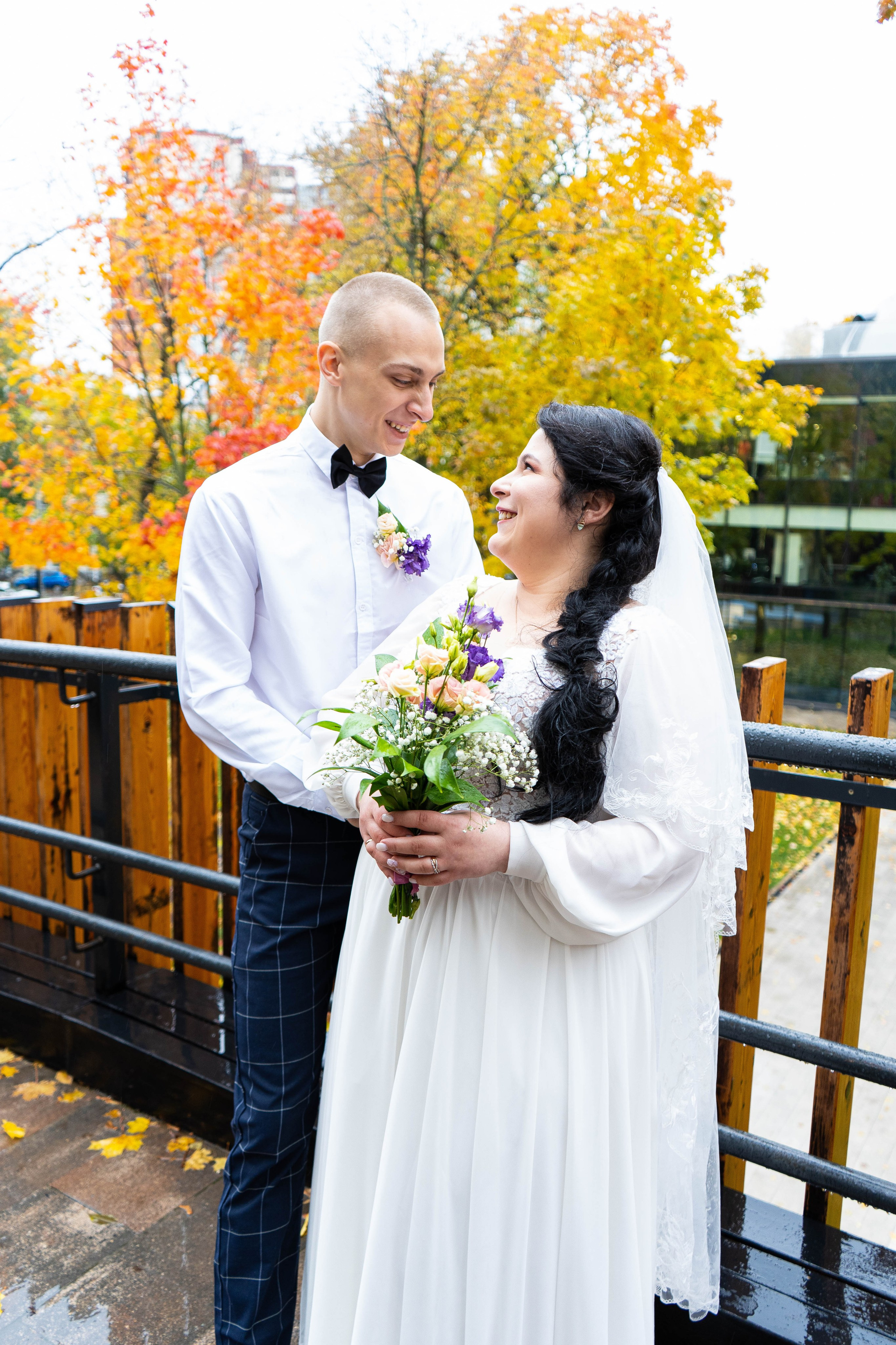 Невеста, черного цвета волосы, белая фата, повернута к жениху и улыбается в Орленок