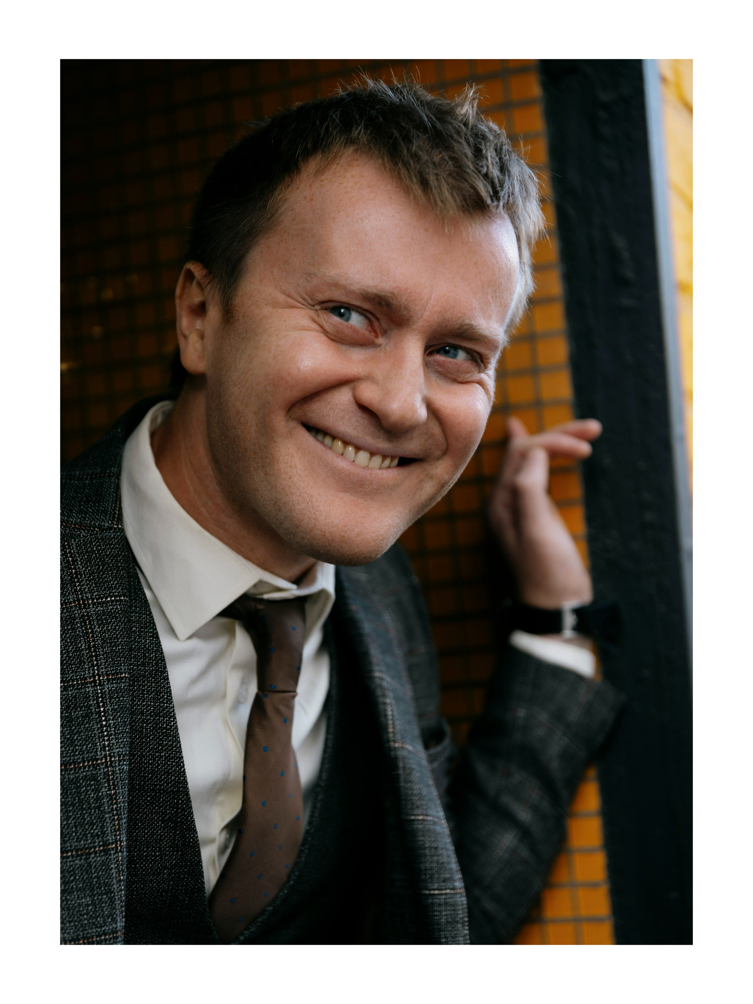 мужчина смеется и смотрит в сторону