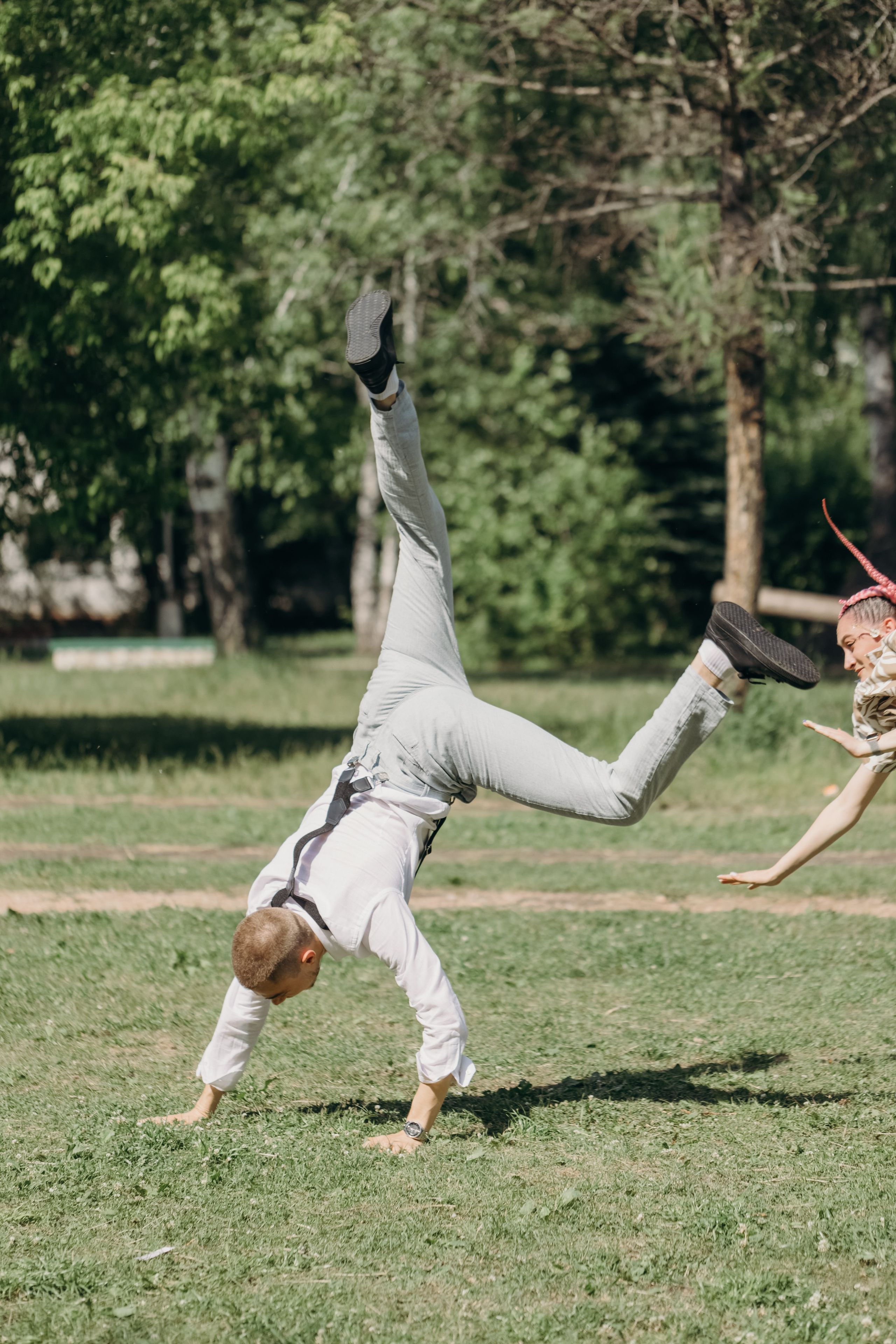 Парень стоит на руках на траве