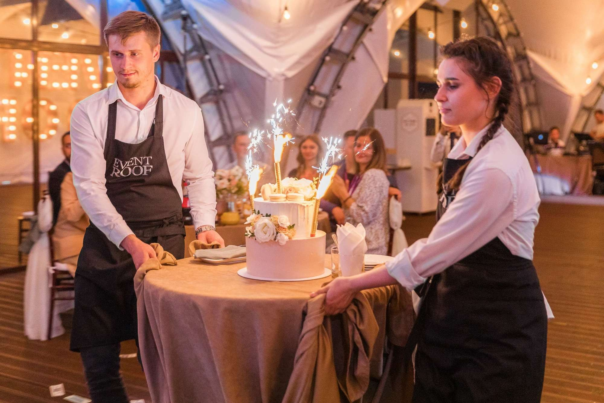 Официанты вывозят свадебный торт