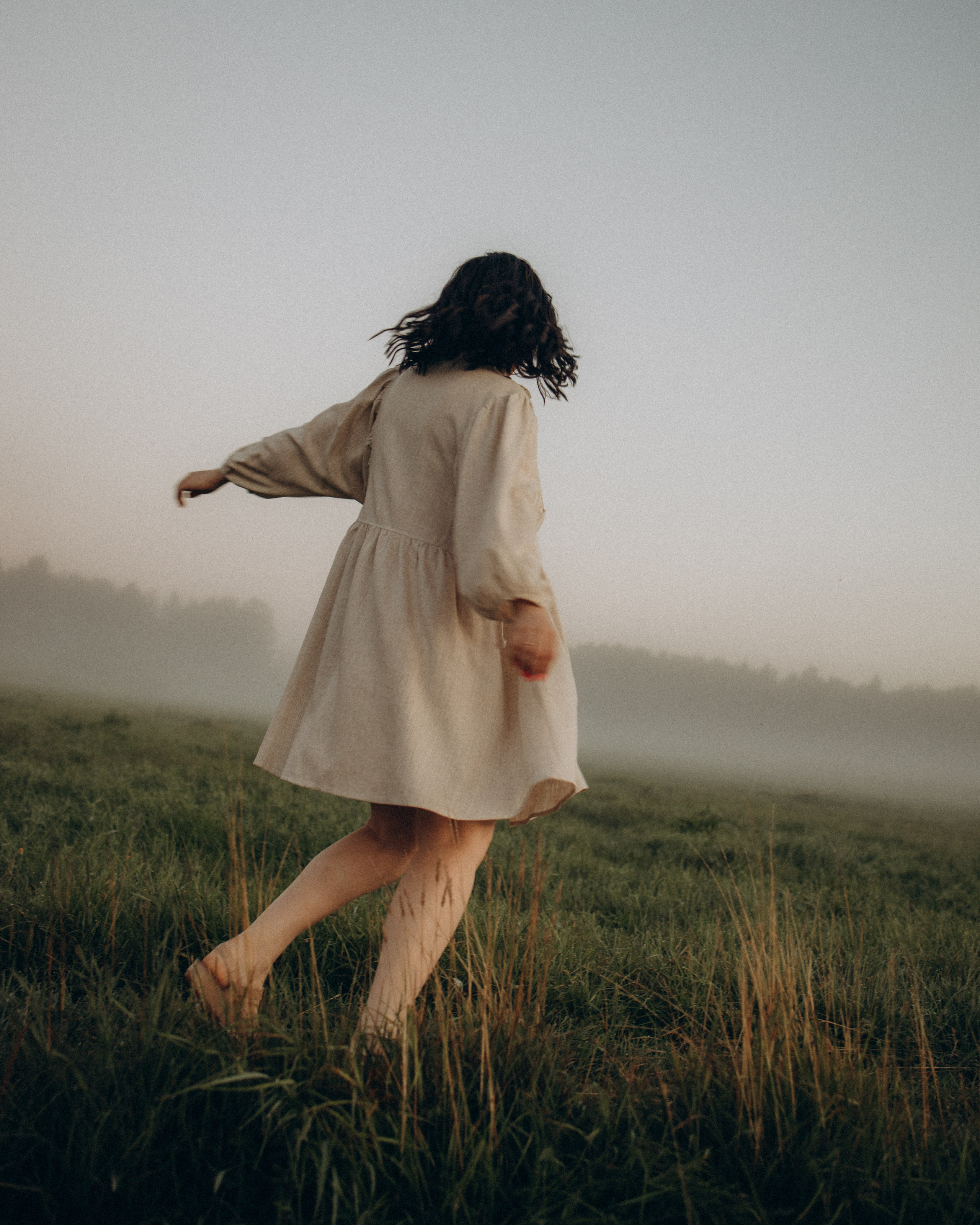 Девушка бегает в поле на рассвете