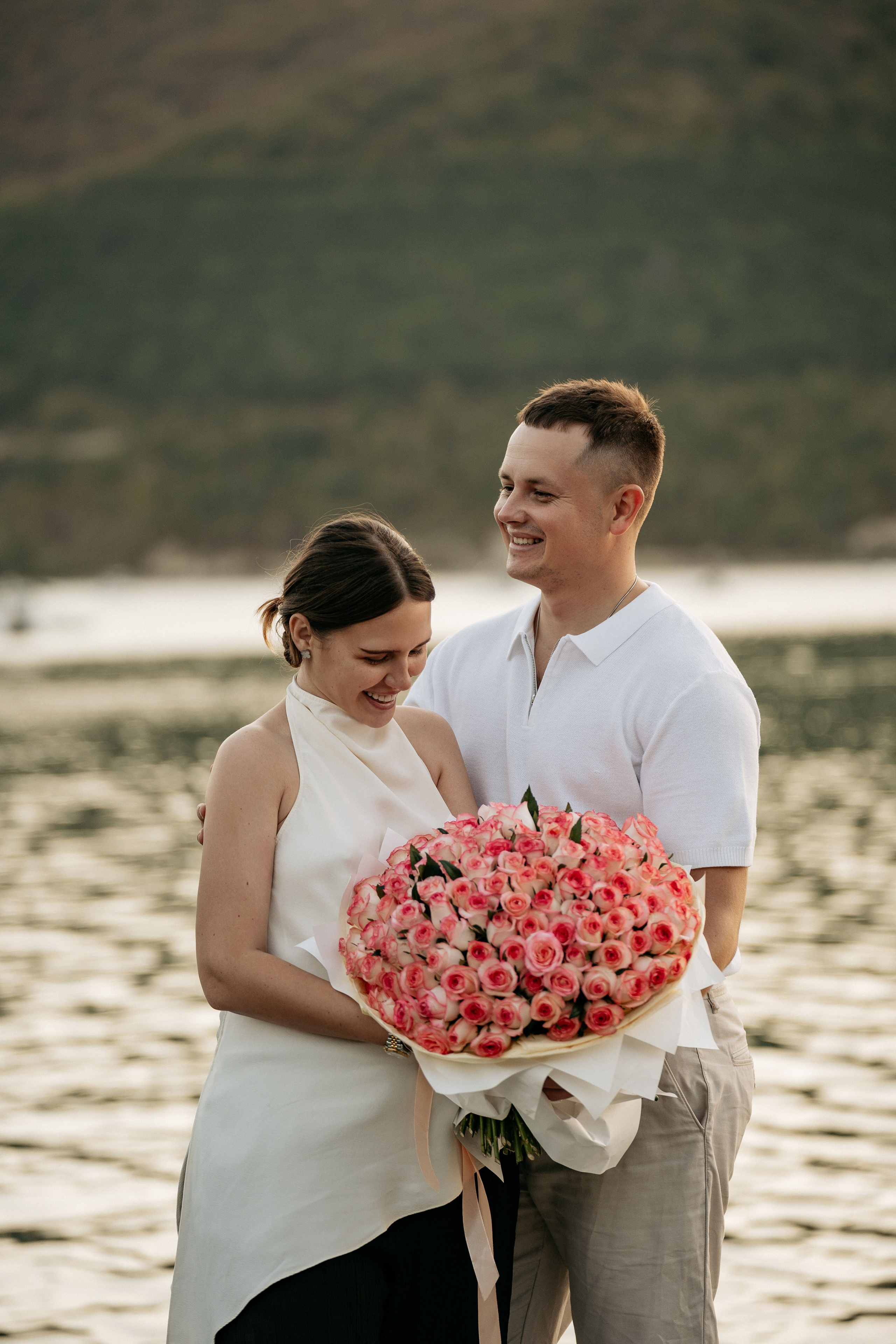 Пара радуется на причале. ФОтография на деревянном причале на озере Абрау-Дюрсо после предложения руки и сердца.