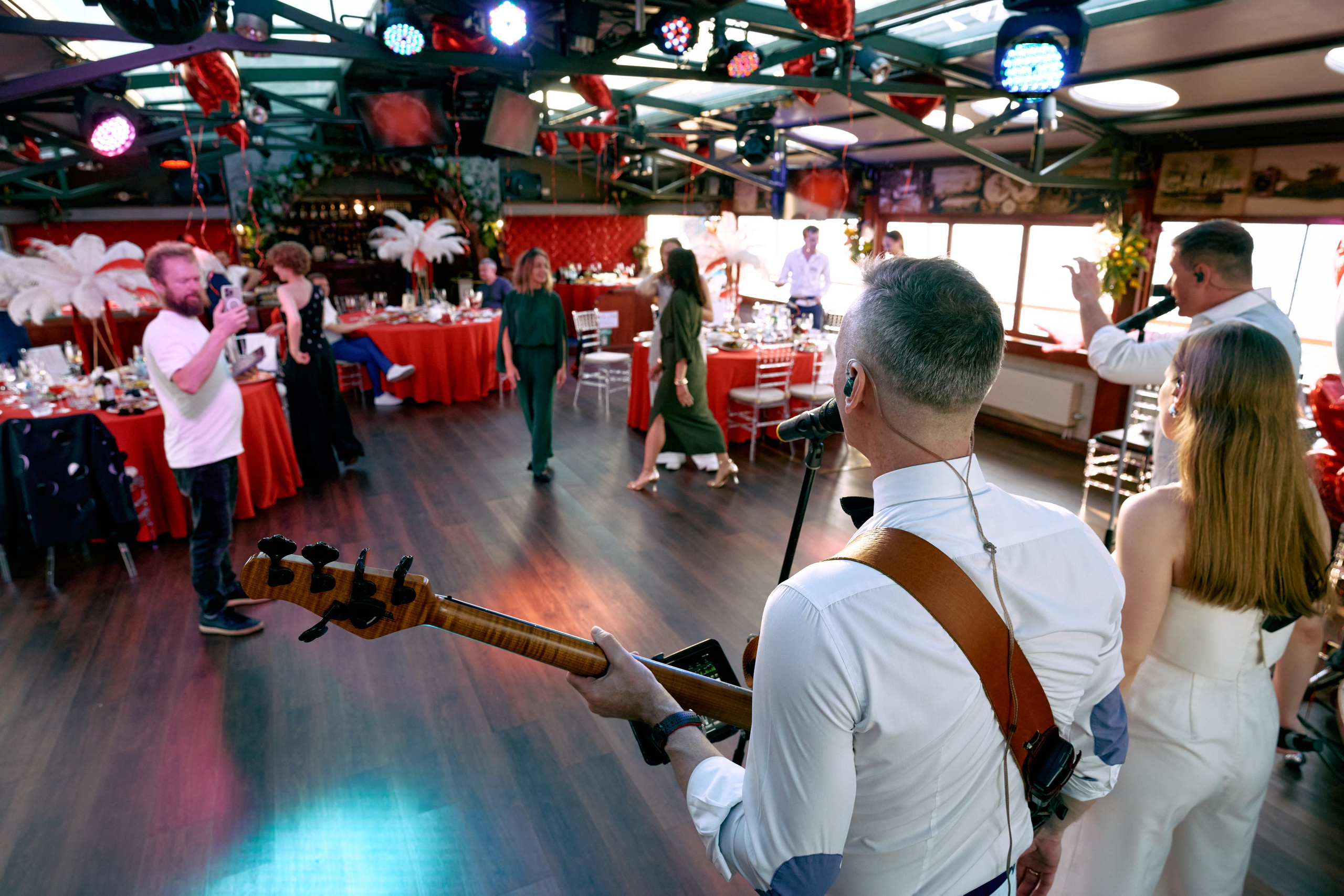 Группа музыкантов в белой одежде поет и играет на инструментах на сцене