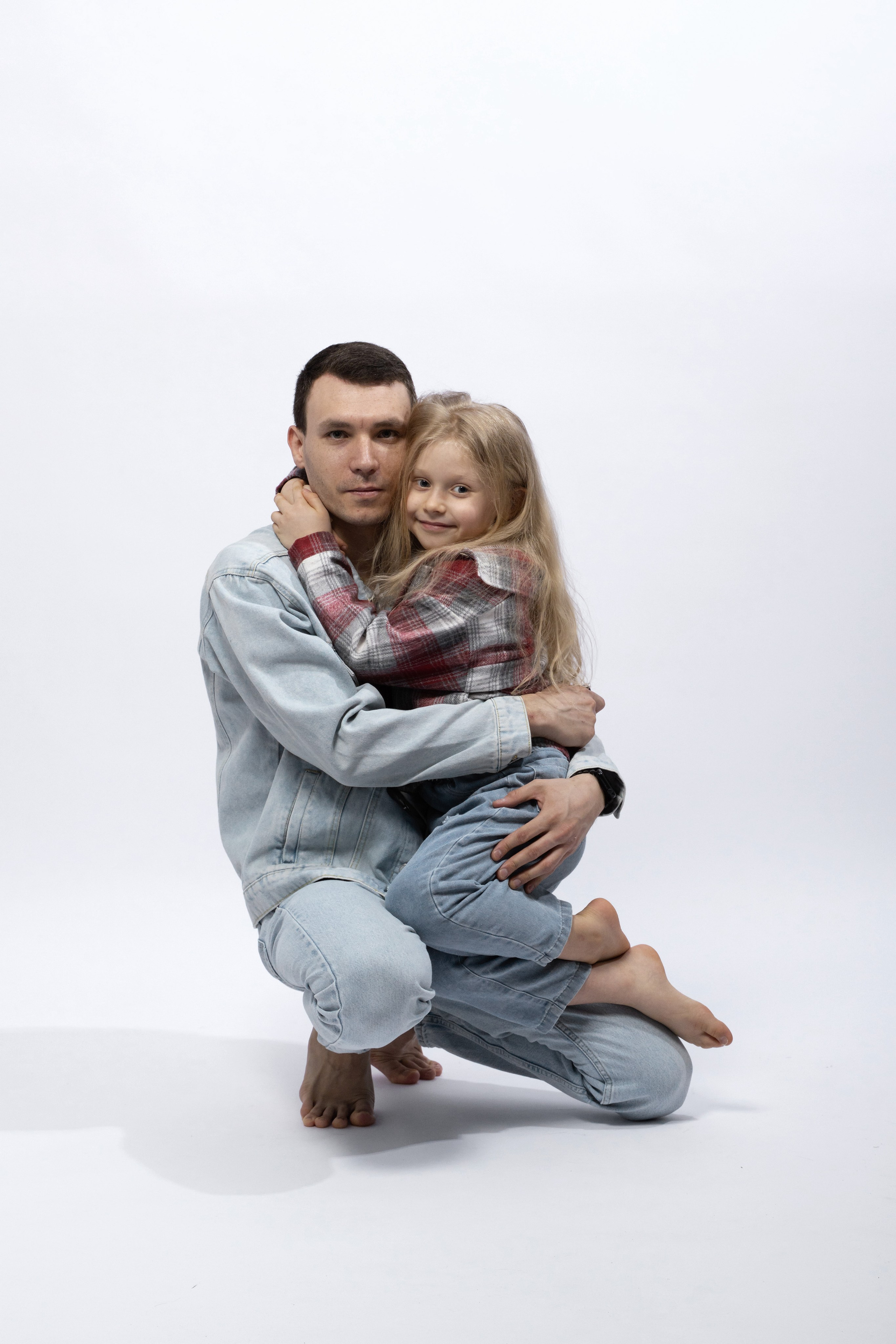 Семья с маленьким ребенком на белом фоне, нежные кадры без фотографа