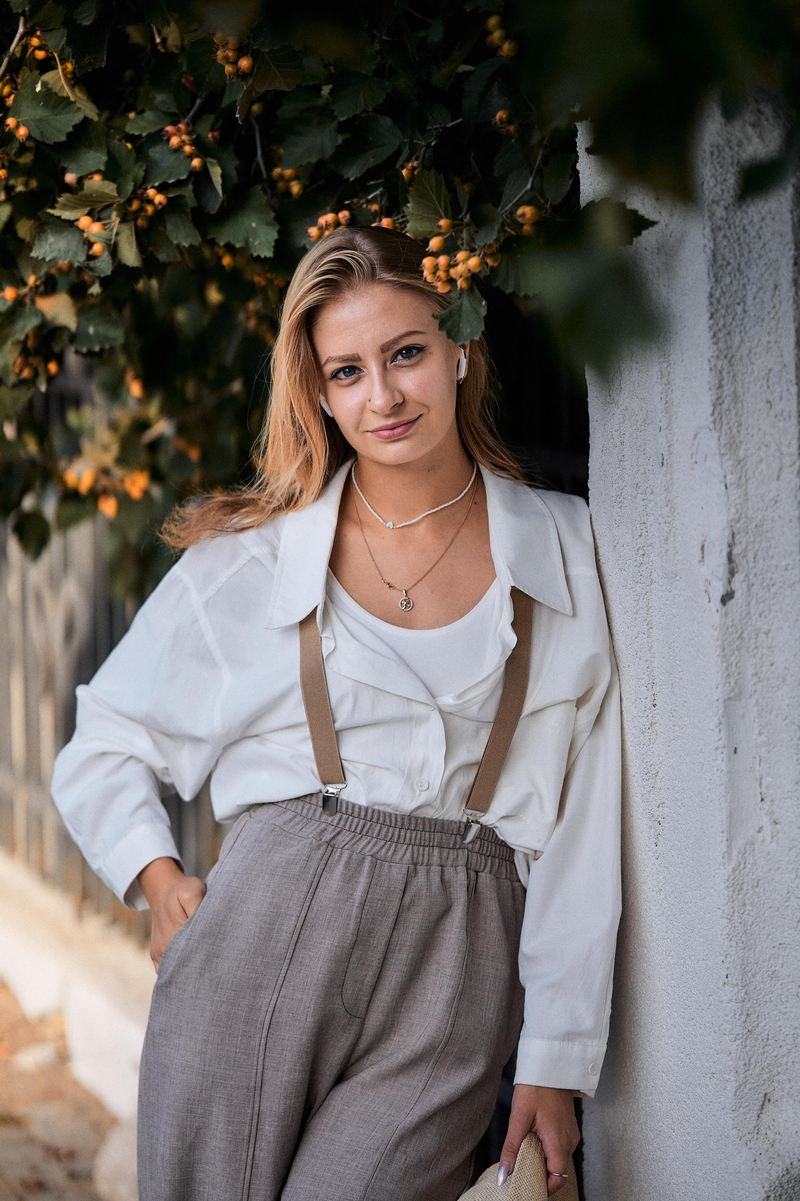 Девушка в серых брюках с подтяжками