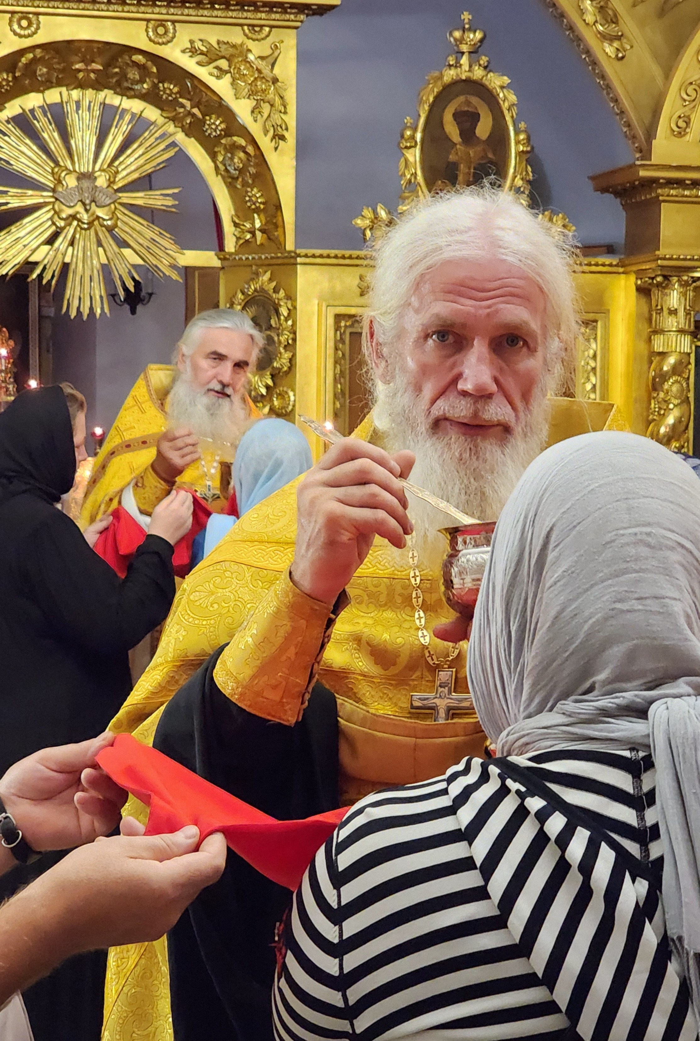 Отец Игорь Мухин причащает