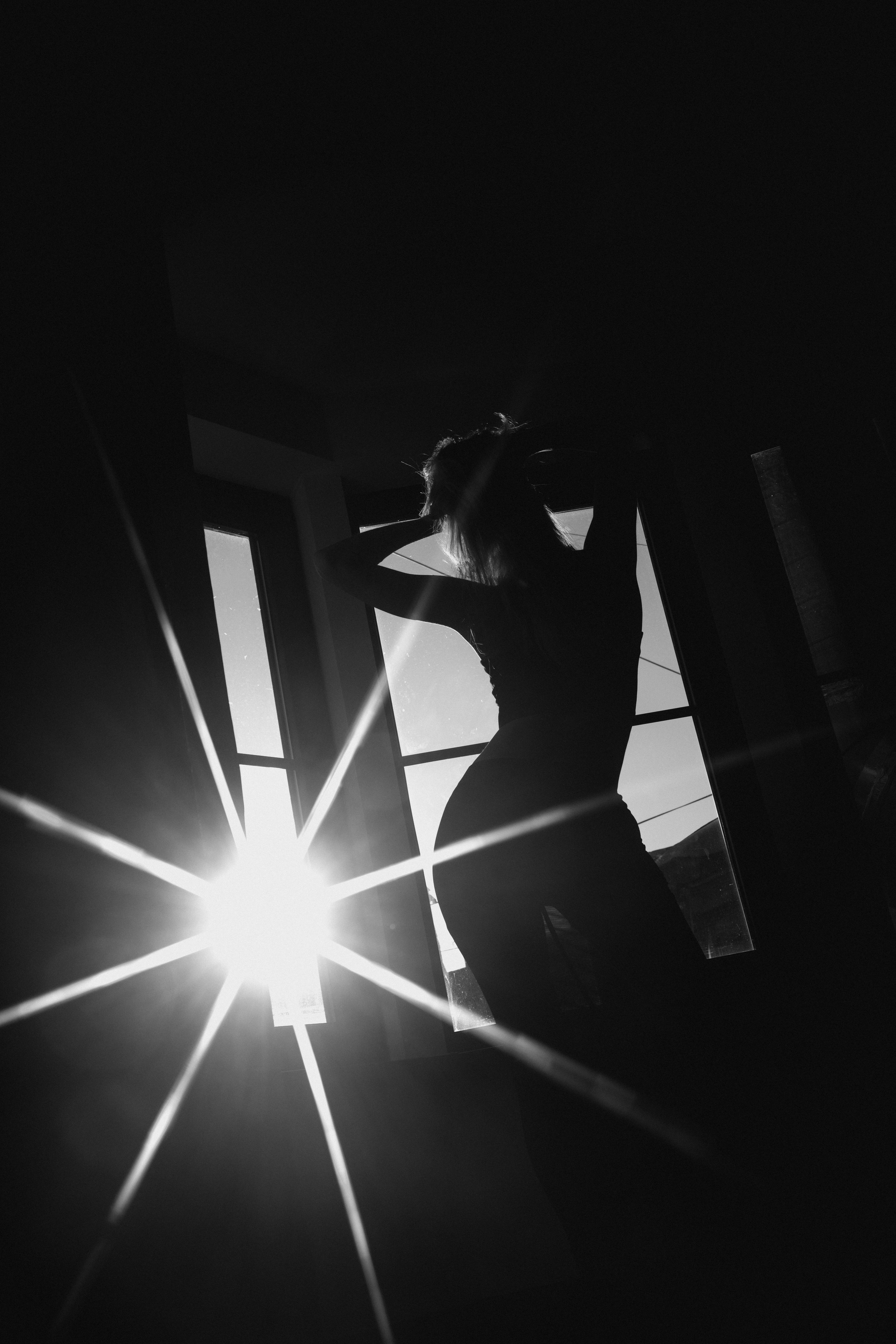 Силуэт девушки в луче света из окна парадной
