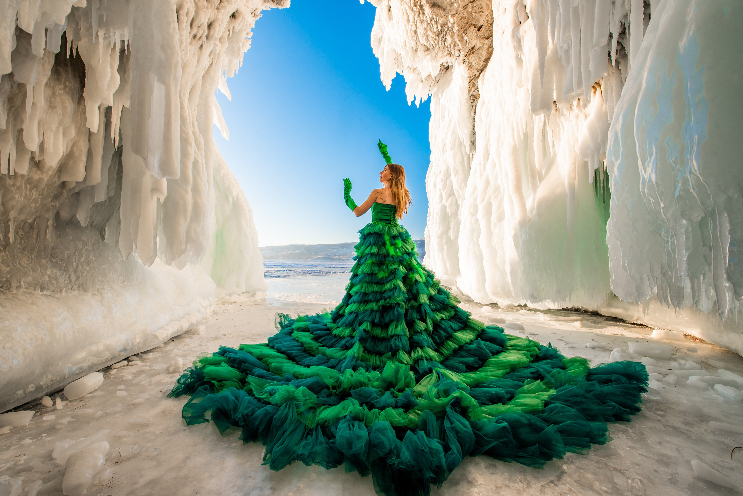 Девушка в ледяном гроте в юбке зеленой фатиновой воланы шлейф на Байкале