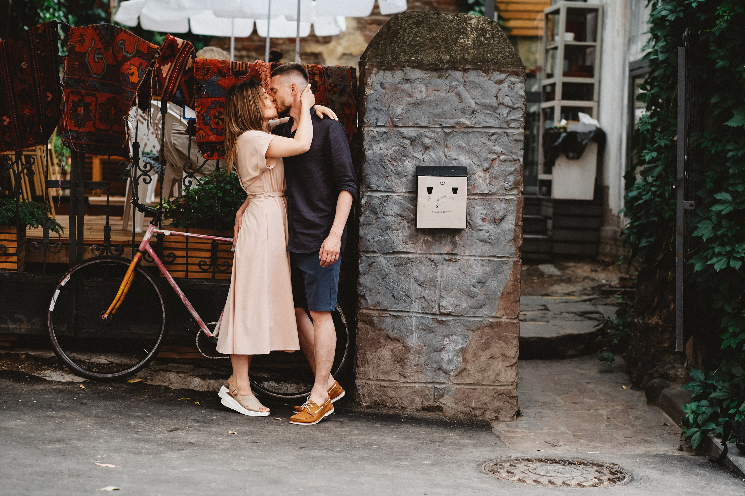 Влюбленная пара целуется. Рядом стоит старый велосипед.