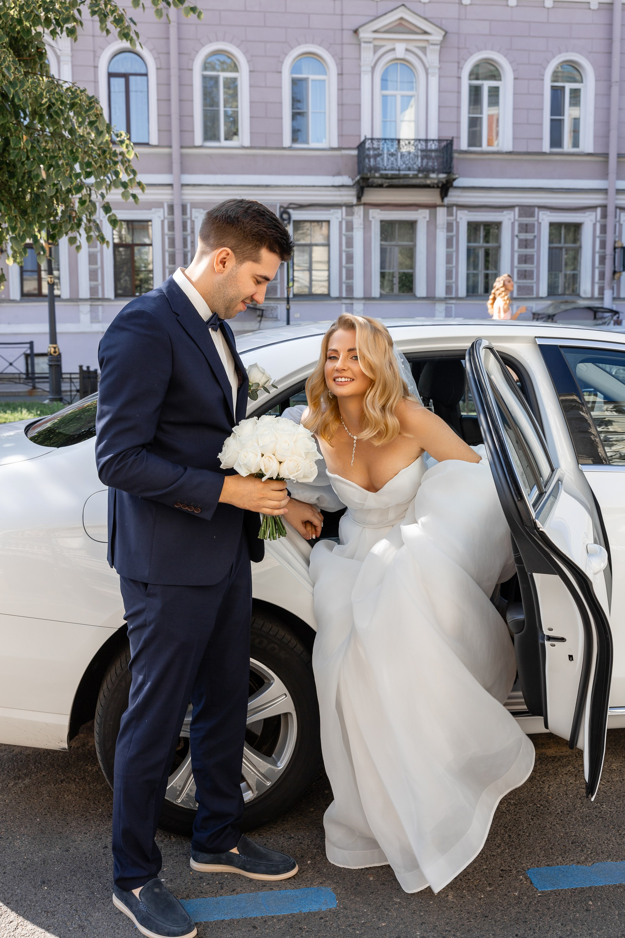 Жених помогает невесте выйти из машины