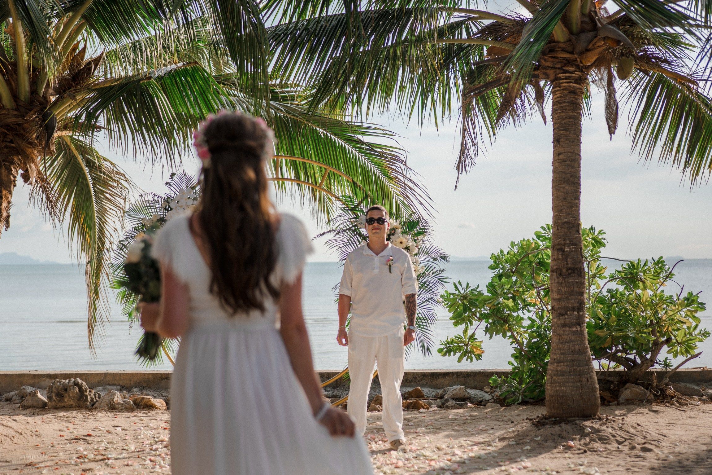 Bride and groom during a romantic beach wedding ceremony on Koh Samui, Thailand, surrounded by tropical scenery and ocean views