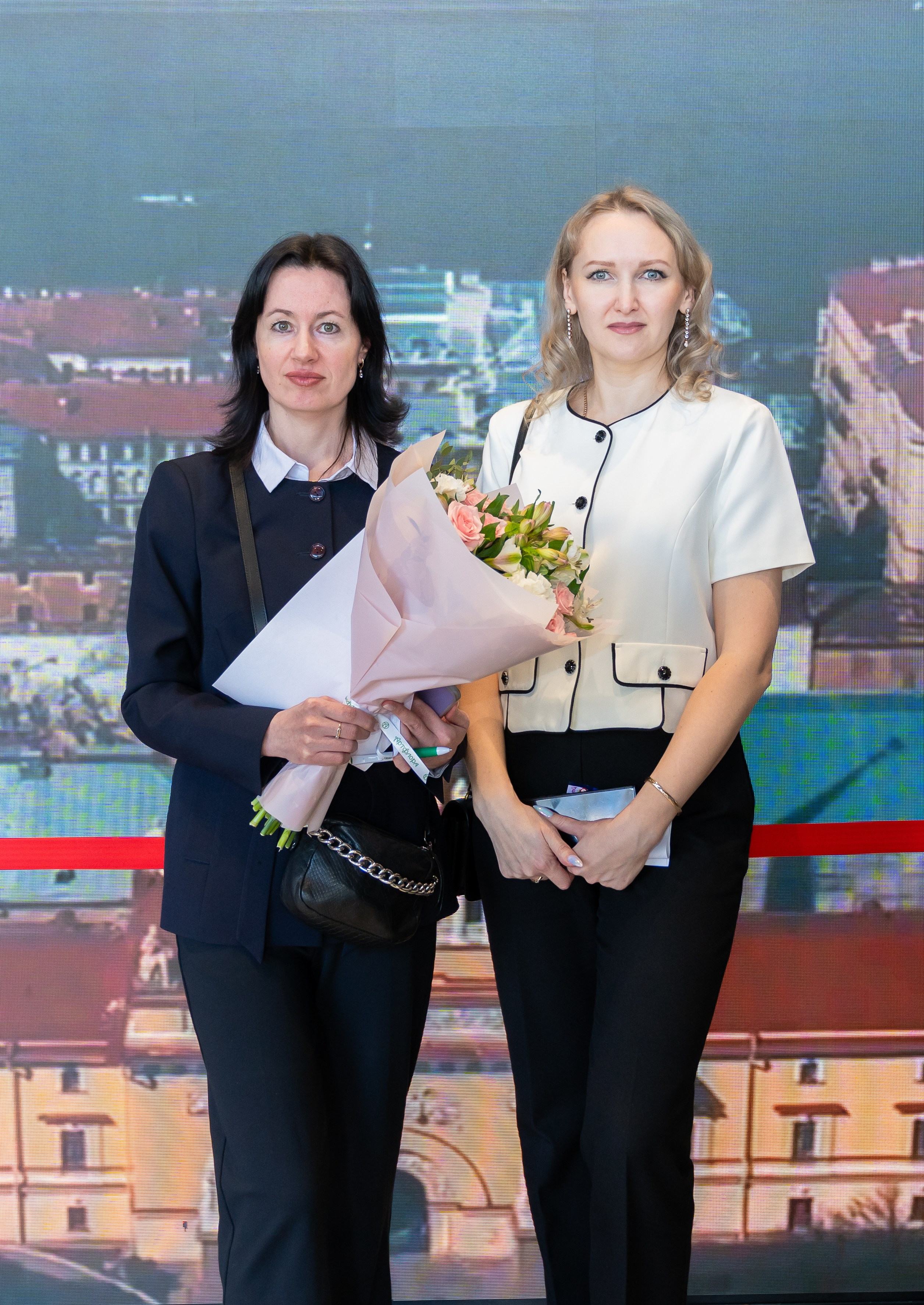 Две женщины на Дне местного самоуправления Санкт-Петербург. Одна из них держит праздничный букет цветов. Фото Евгения Мальцева.