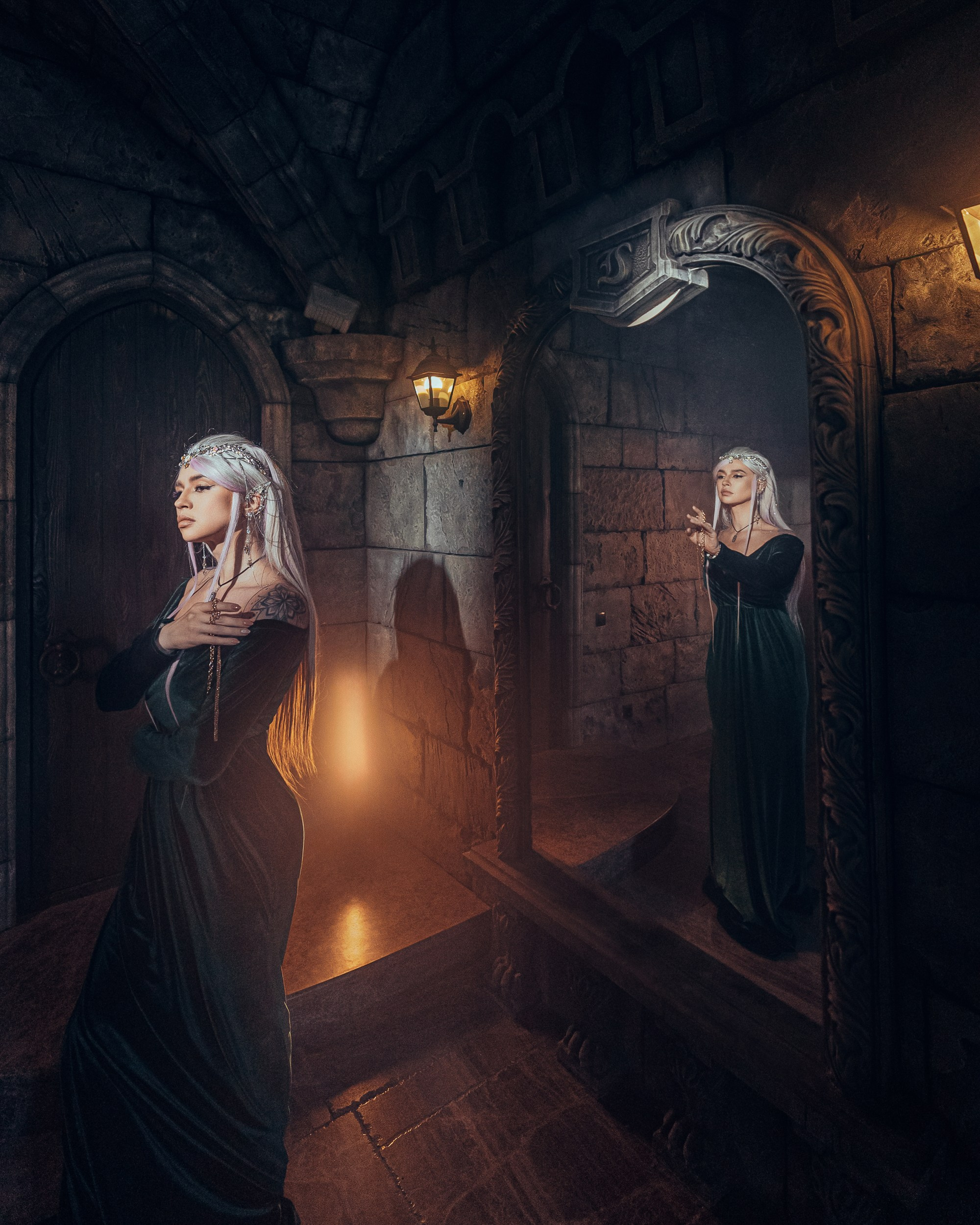 Две модели с платиновыми волосами и готическими нарядами в коридоре со свечами, создающими мистическую атмосферу замка Гарибальди.