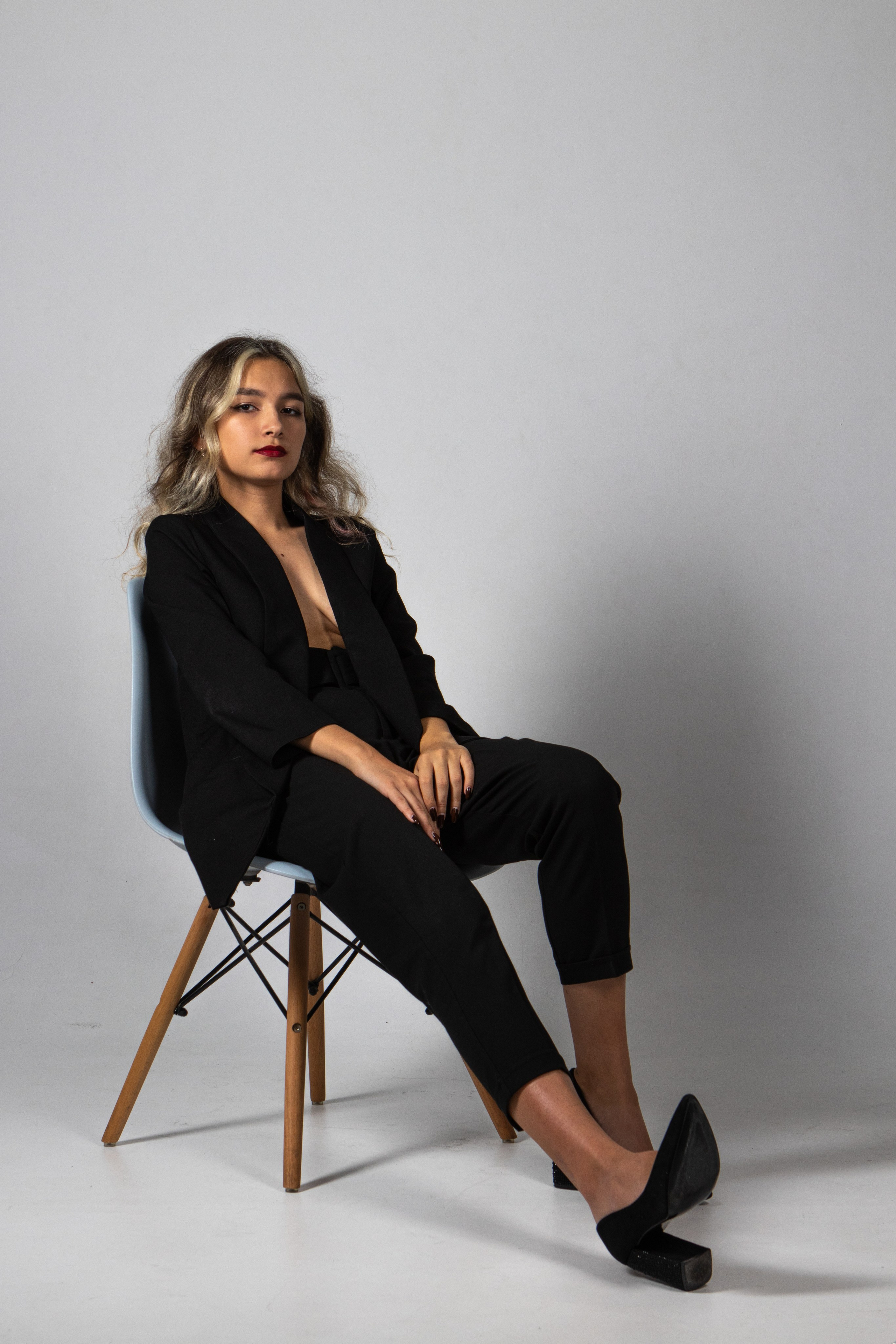 Девушка на циклораме сидит на стуле