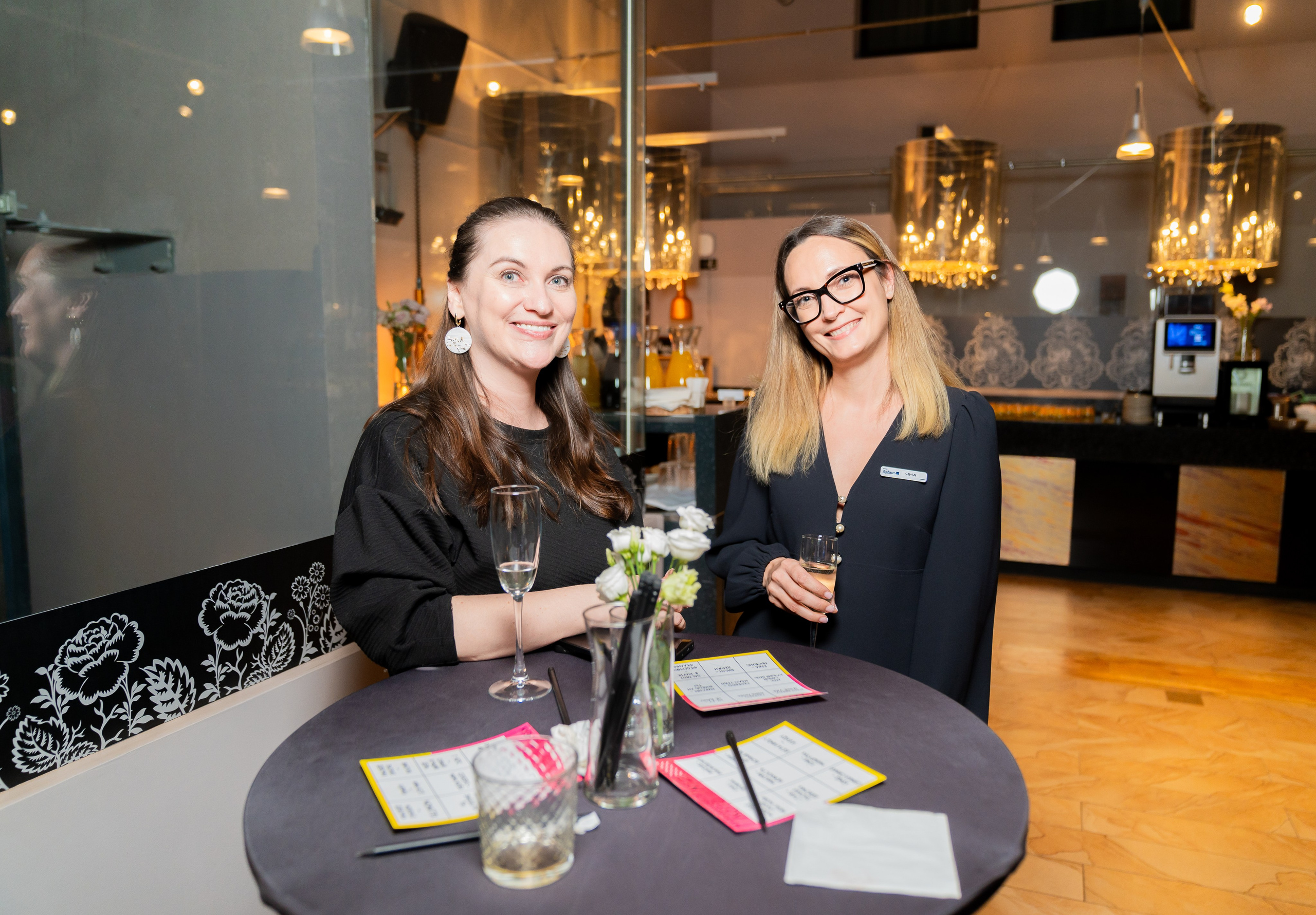 ве улыбчивые девушки с бокалами шампанского и лотерейными билетами за столом на корпоративе Radisson Sonya. Фото Евгения Мальцева.