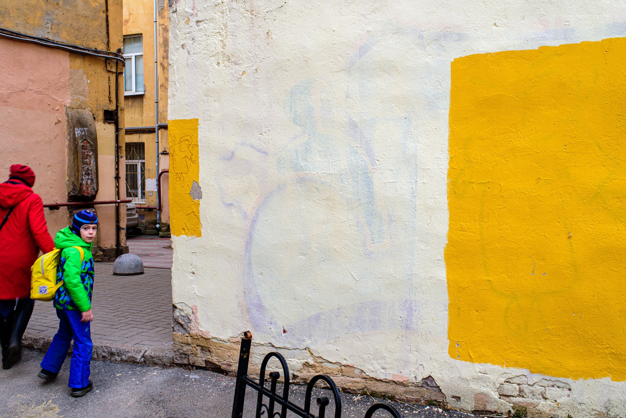 Ребёнок смотрит на закрашенное граффити с Иисусом Христом