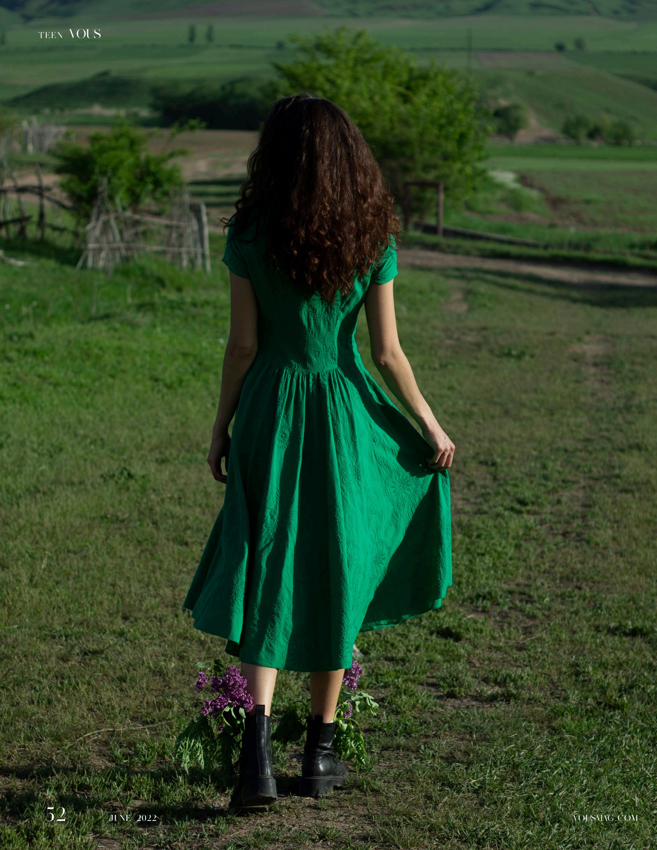 Девушка в зеленом платье и цветами в ботинках уходит в поля 