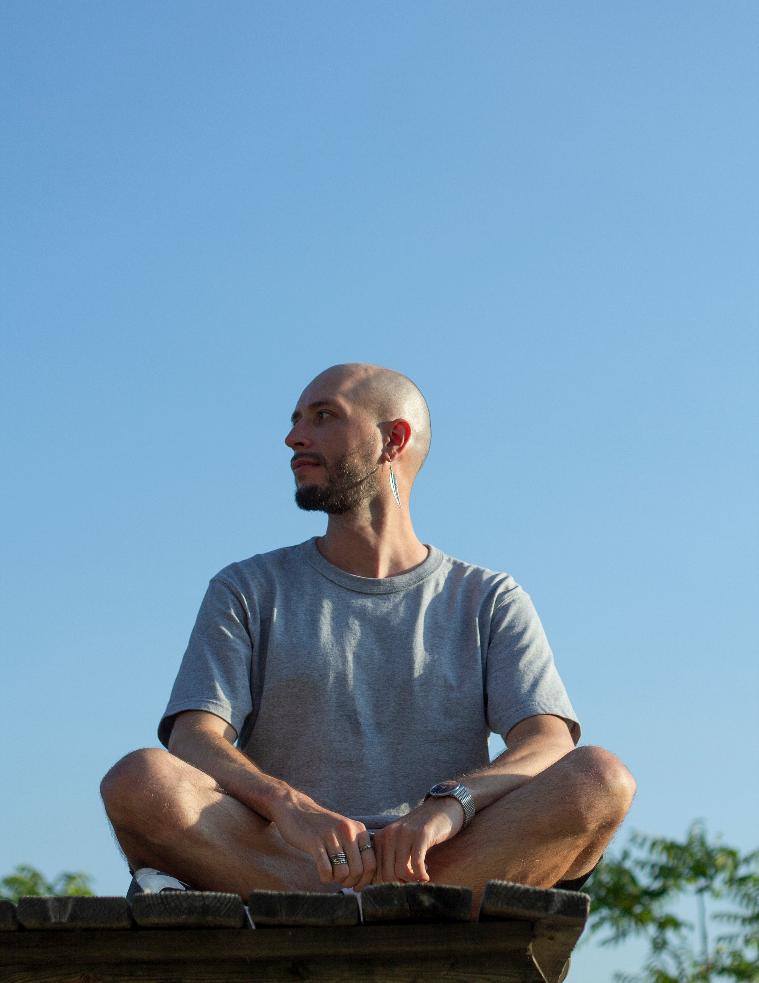 Мужчина сидит, скрестив ноги, в лучах закатного солнца