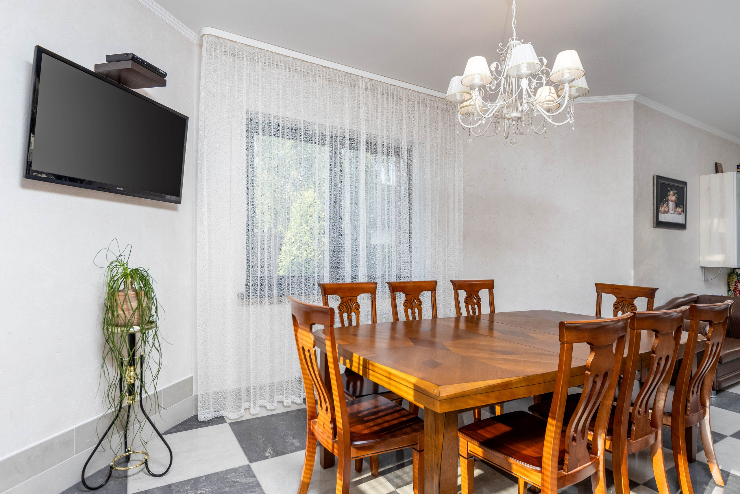 Столовая с ТВ и большим деревянным столом в частном коттедже под Минском