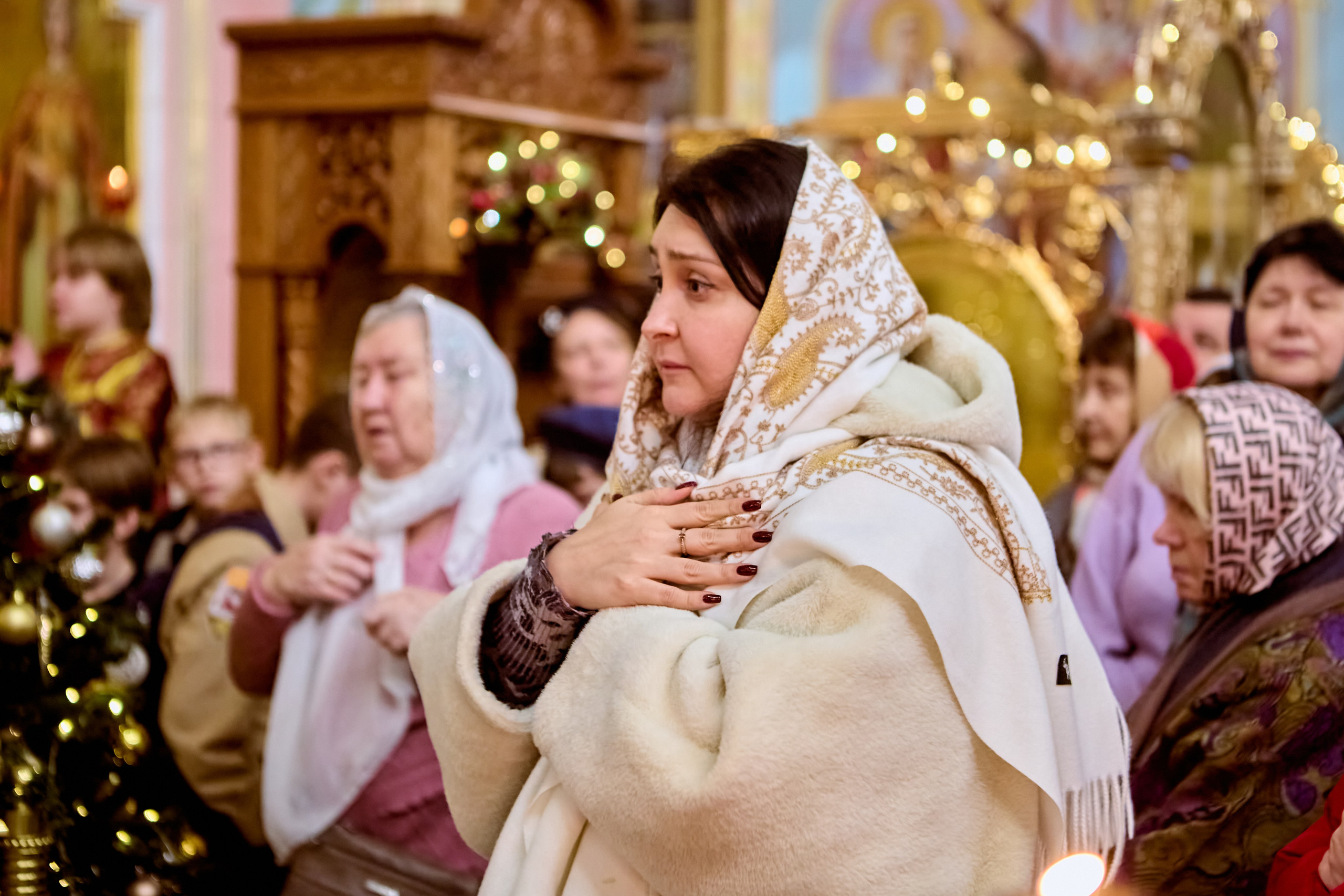 Портрет девушки в светлой одежде стоит к причастию со сложенными крестом руками на груди