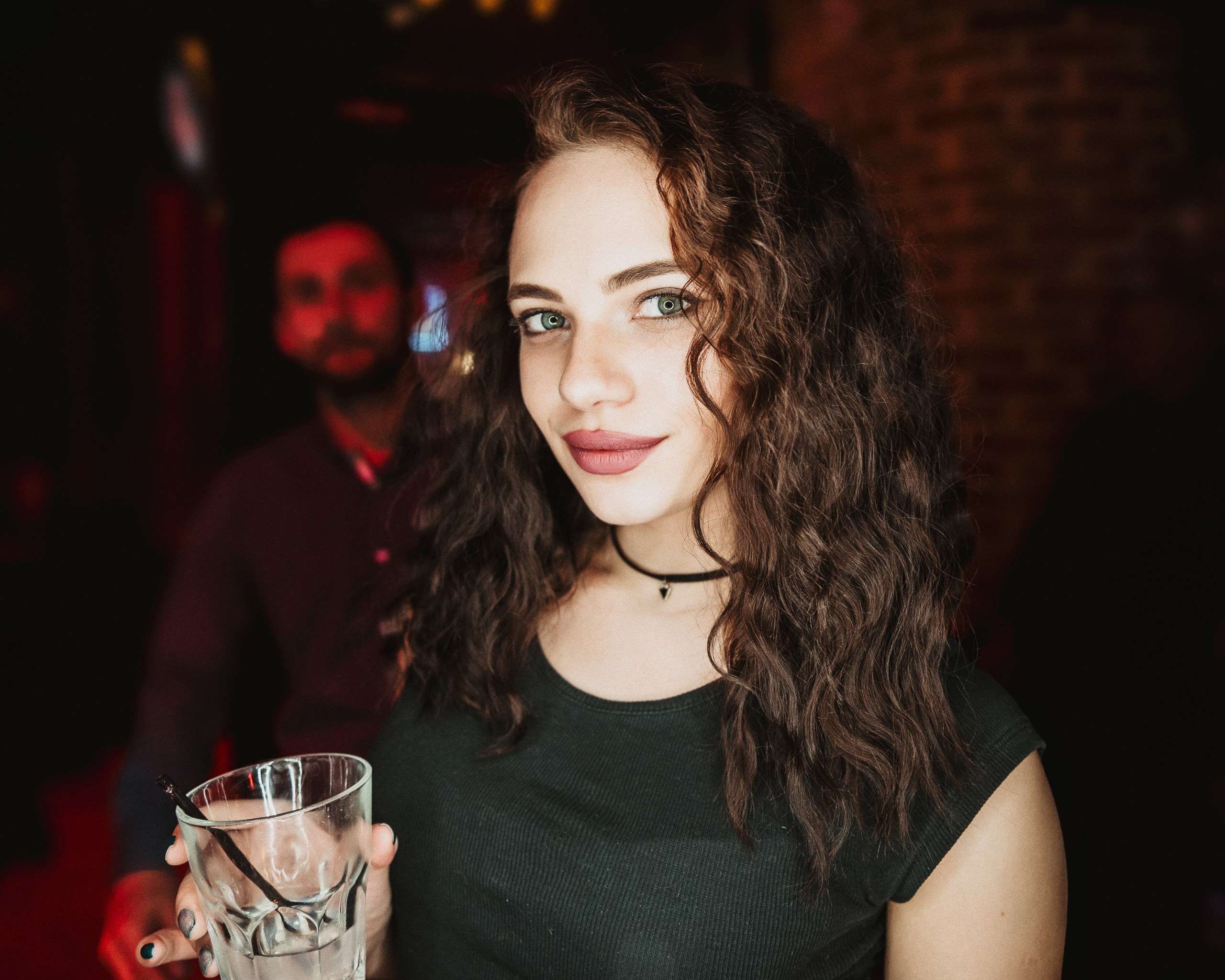 Крупный план гостей вечеринки с коктейлями в руках у барной стойки.