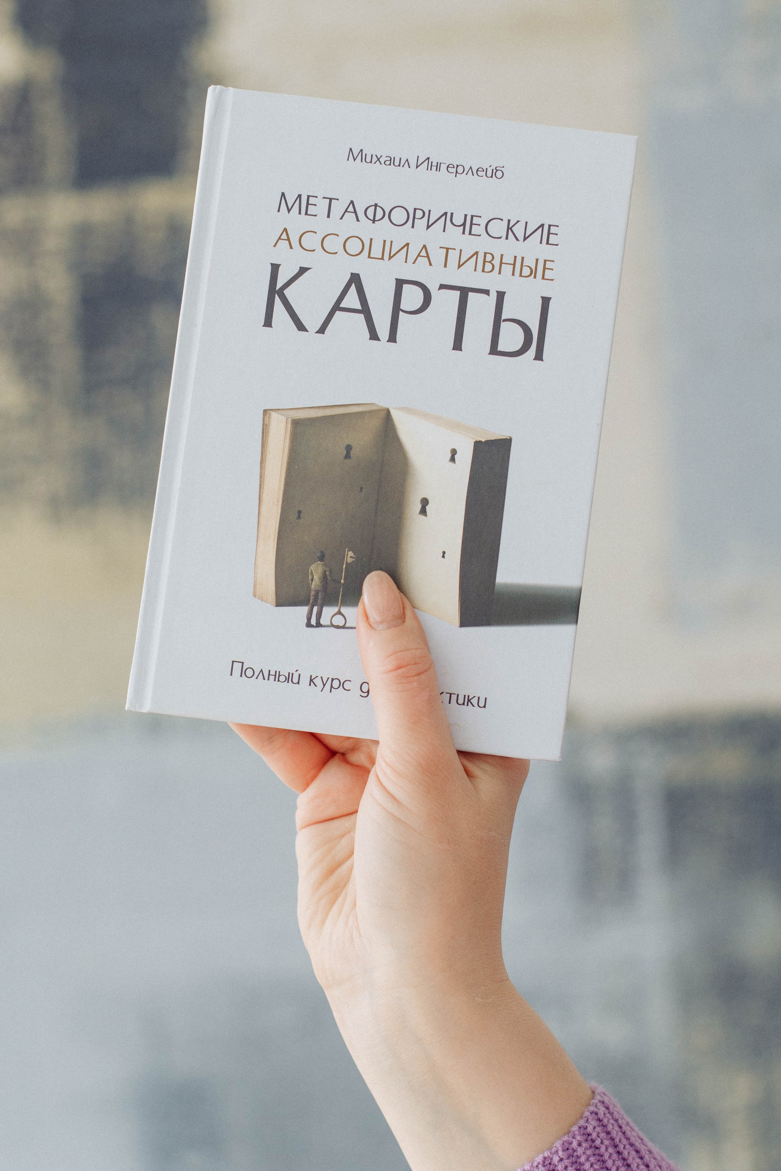 Психолог держит в руках книгу по психологии. Кадр, подчеркивающий экспертность и образование.