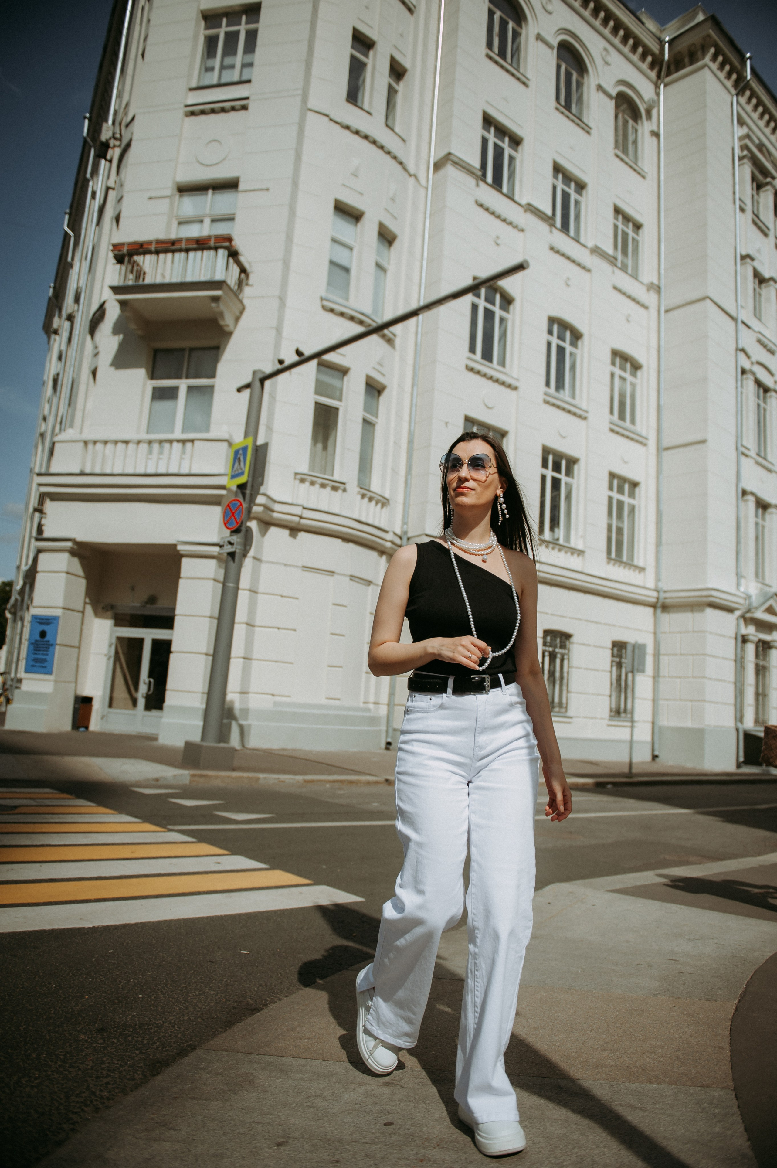 девушка переходит дорогу, на фоне красивого здания, уличное фото