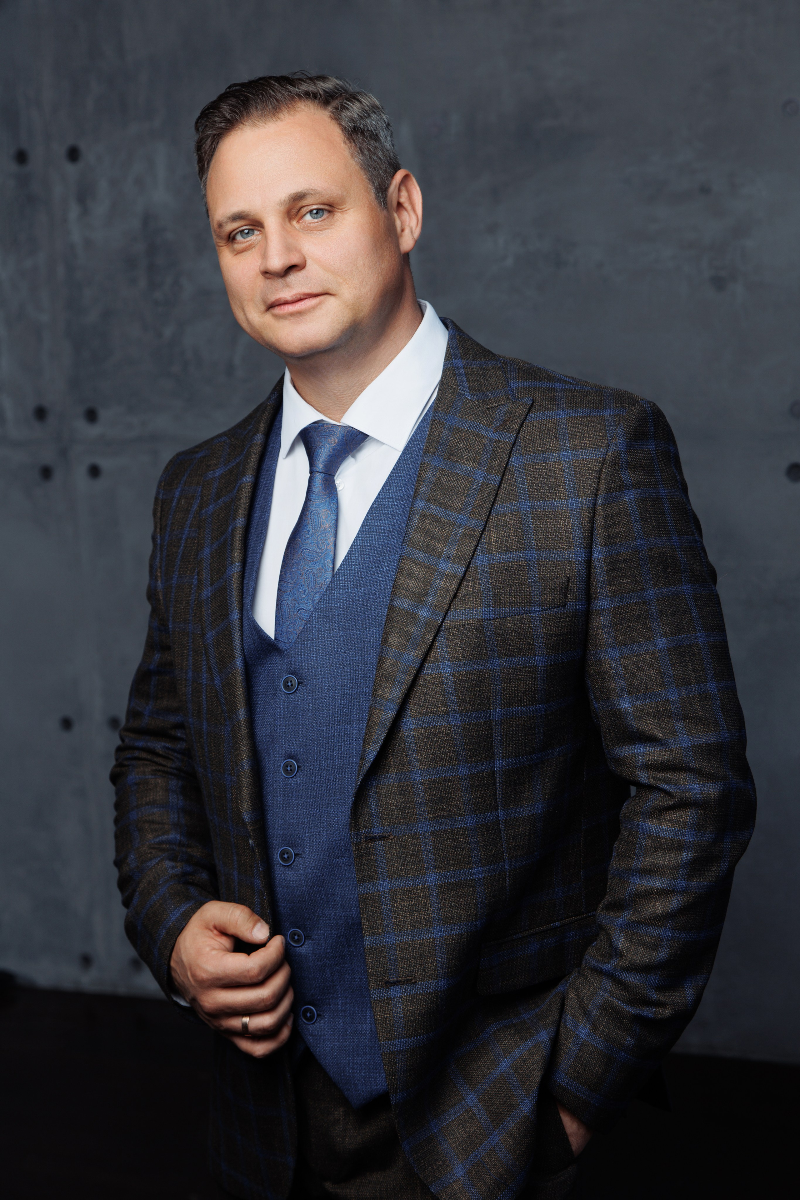 Деловой портрет мужчины на темном фактурном студийном фоне.