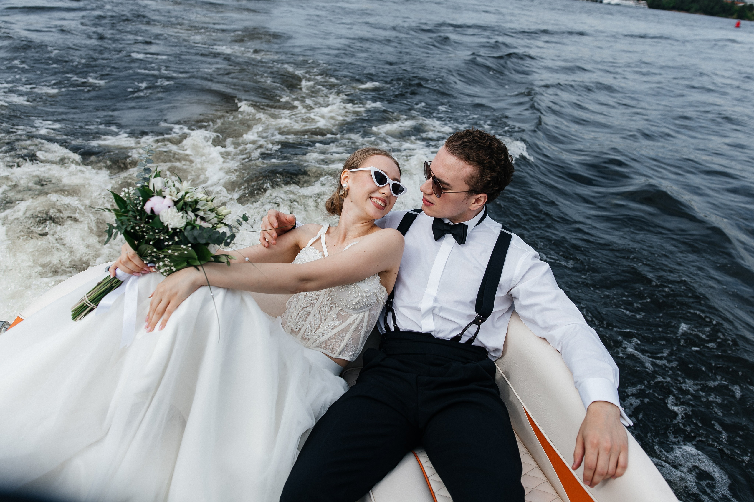 Супруги катаются на лодке по воде в Петербурге, наслаждаясь моментом и видом друг на друга.фотографспб