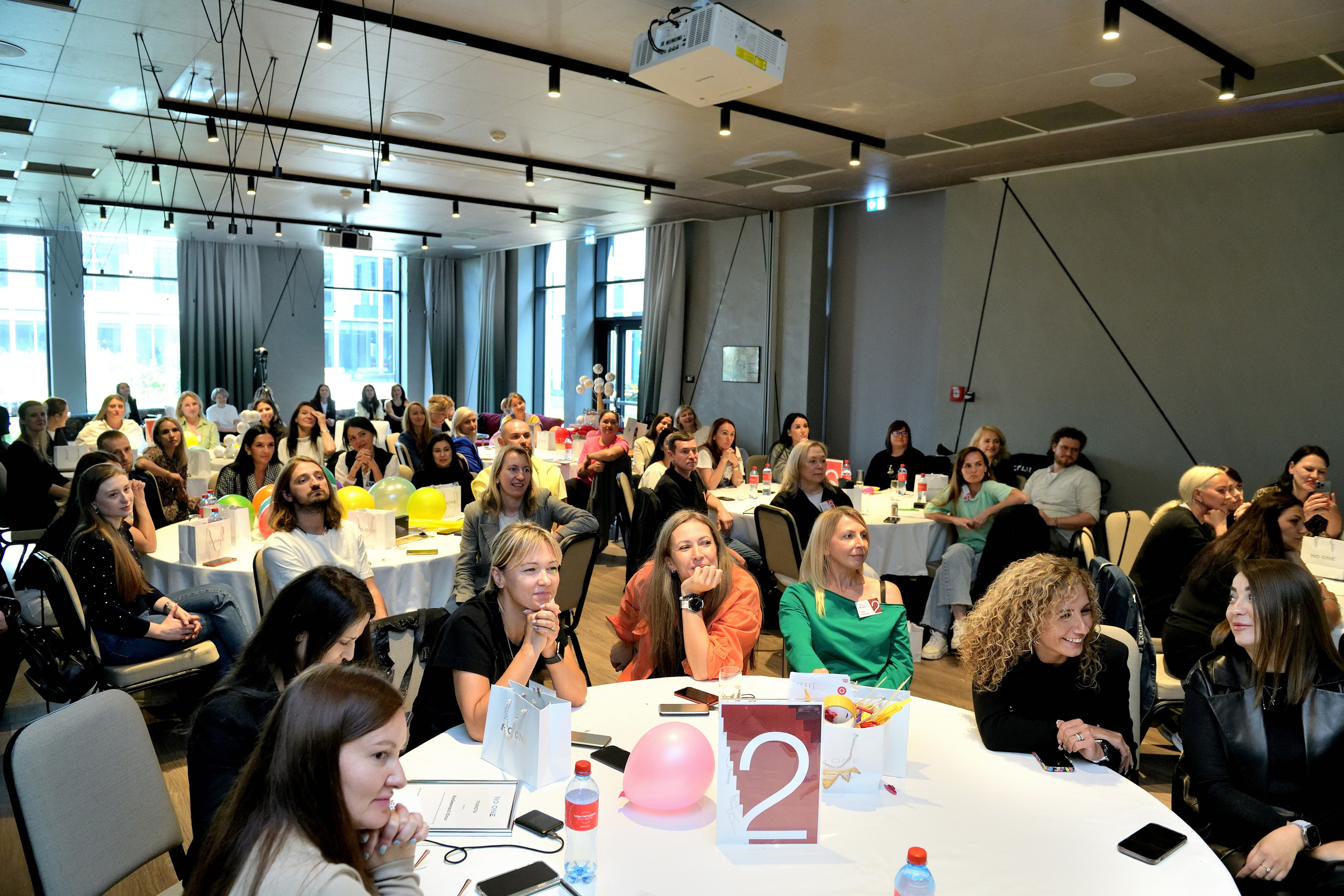 "Сотрудники на бизнес-тренинге слушают спикера".