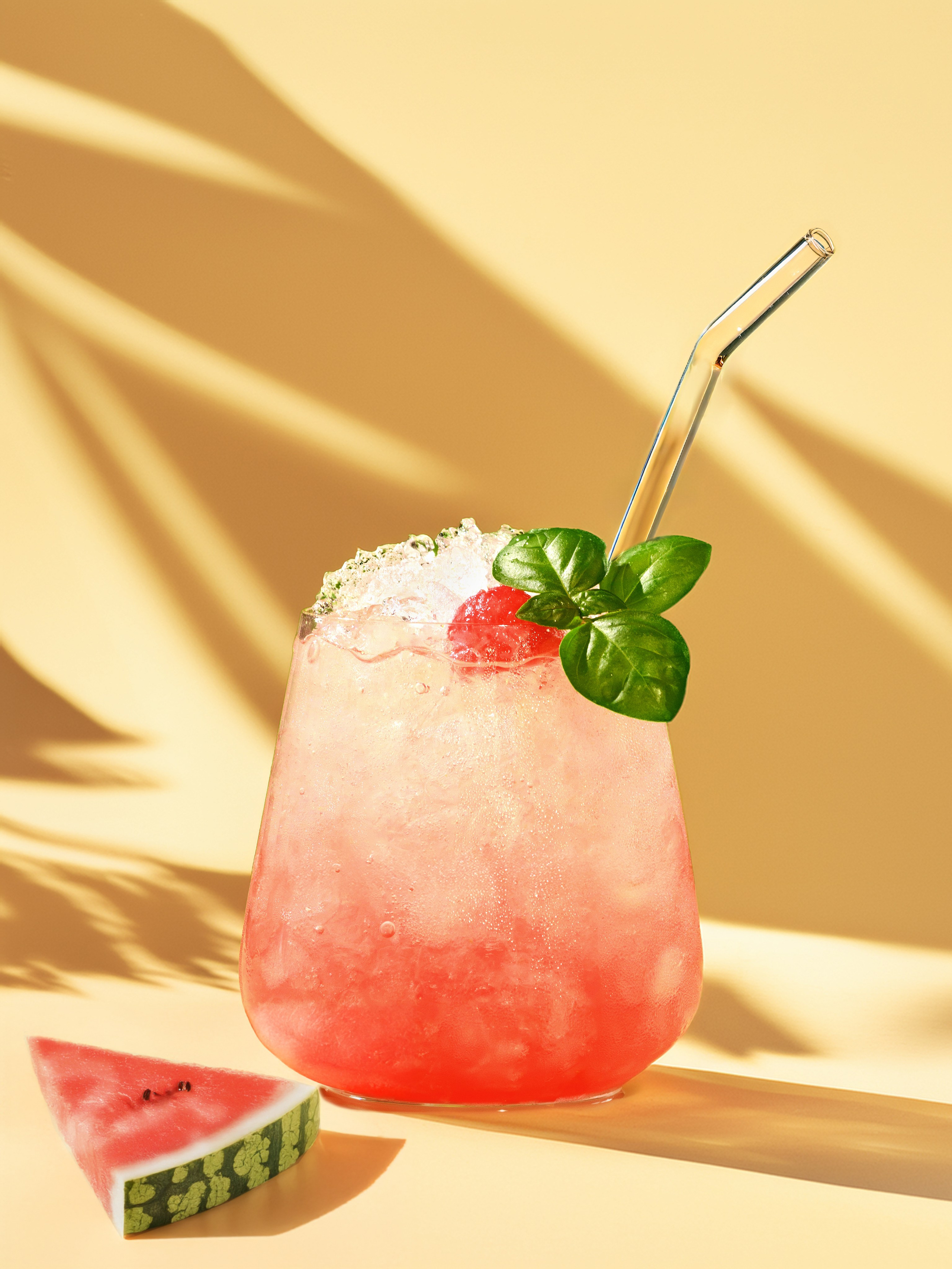 арбузный коктейль со льдом и базиликом на солнечном желтом фоне. Фудфото арбузного коктейля