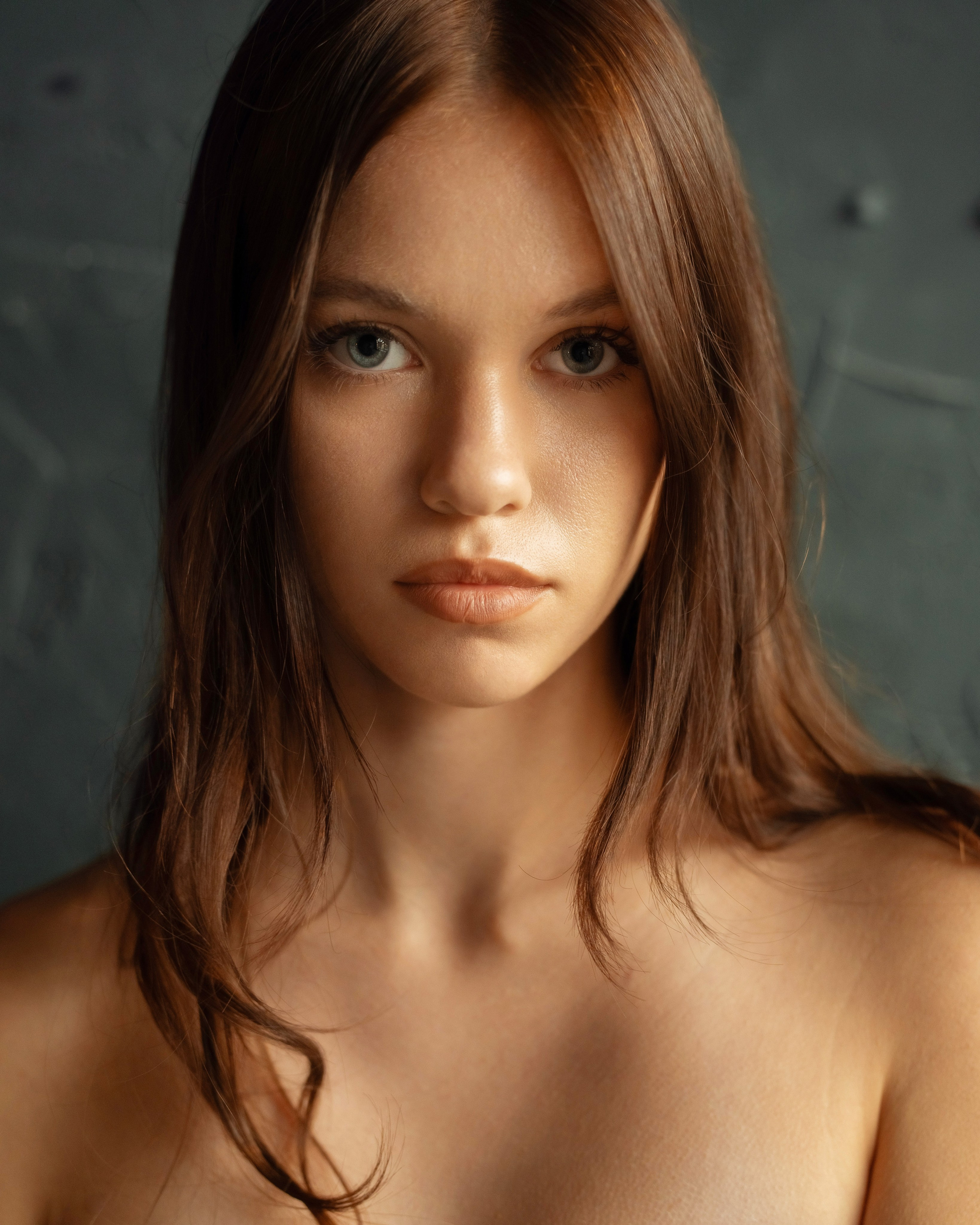 Студийная фотосессия с естественным светом девушки. Студия в темных тонах