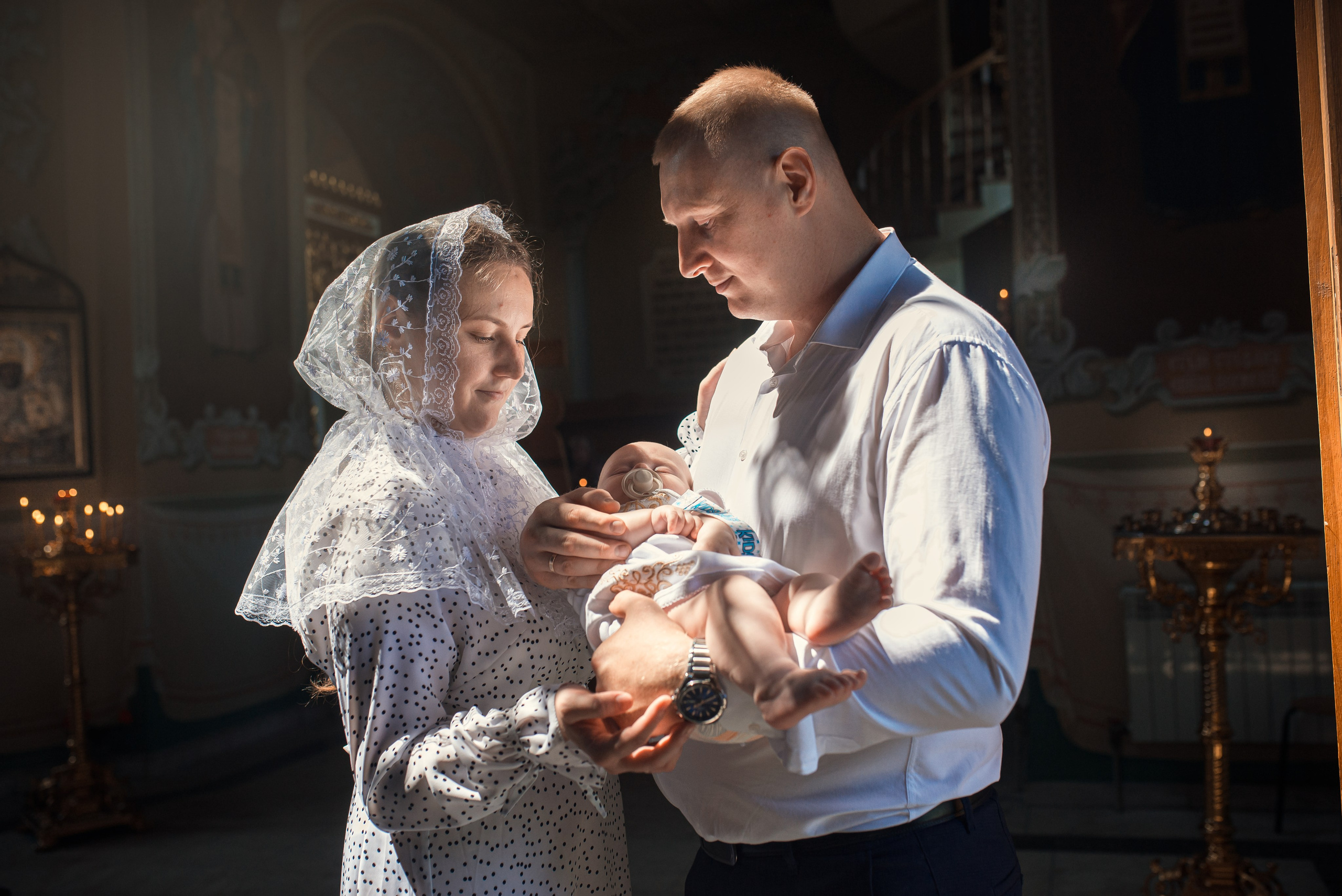 покрестили малыша в покровском соборе города саратова, ребенок у папы и мамы на руках, профессиональный фотограф 