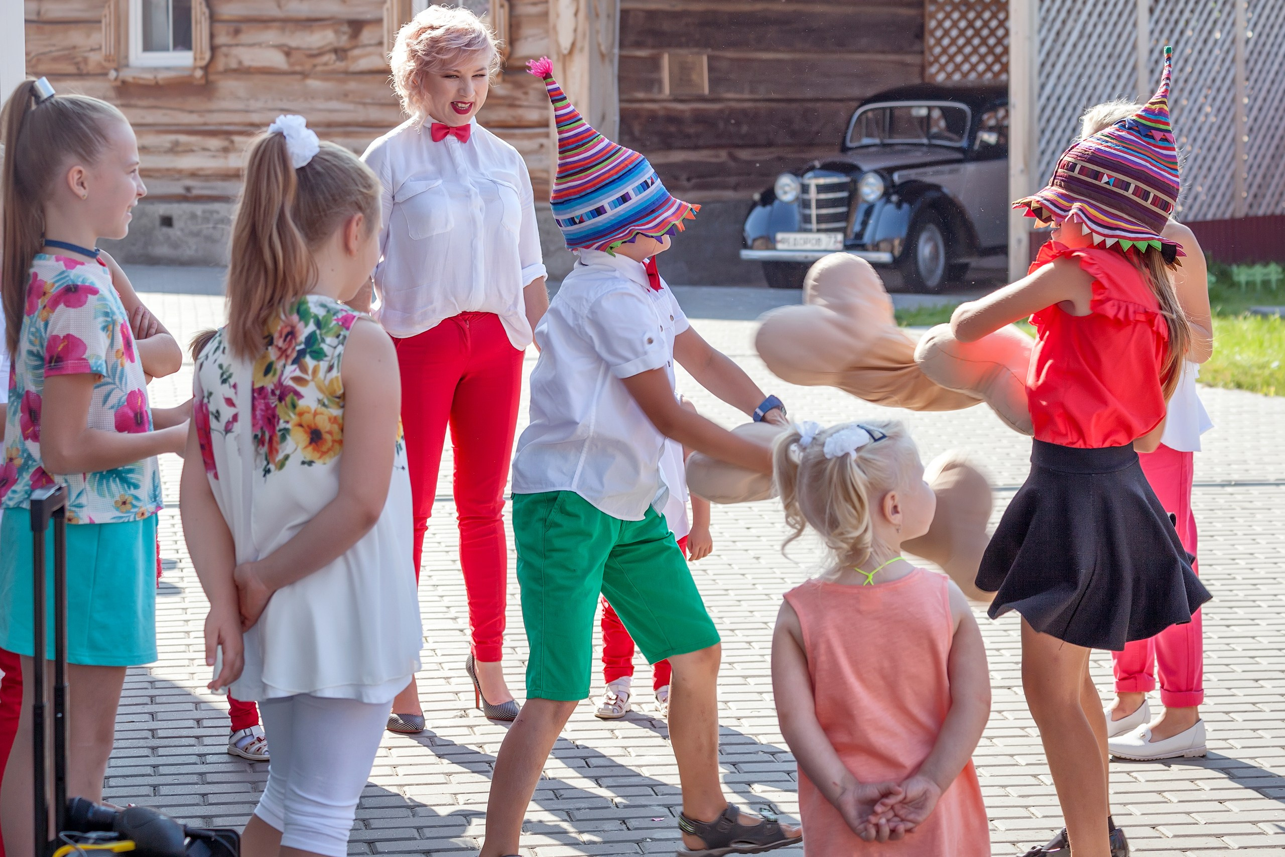 Дети в колпаках сражаются на детском празднике.