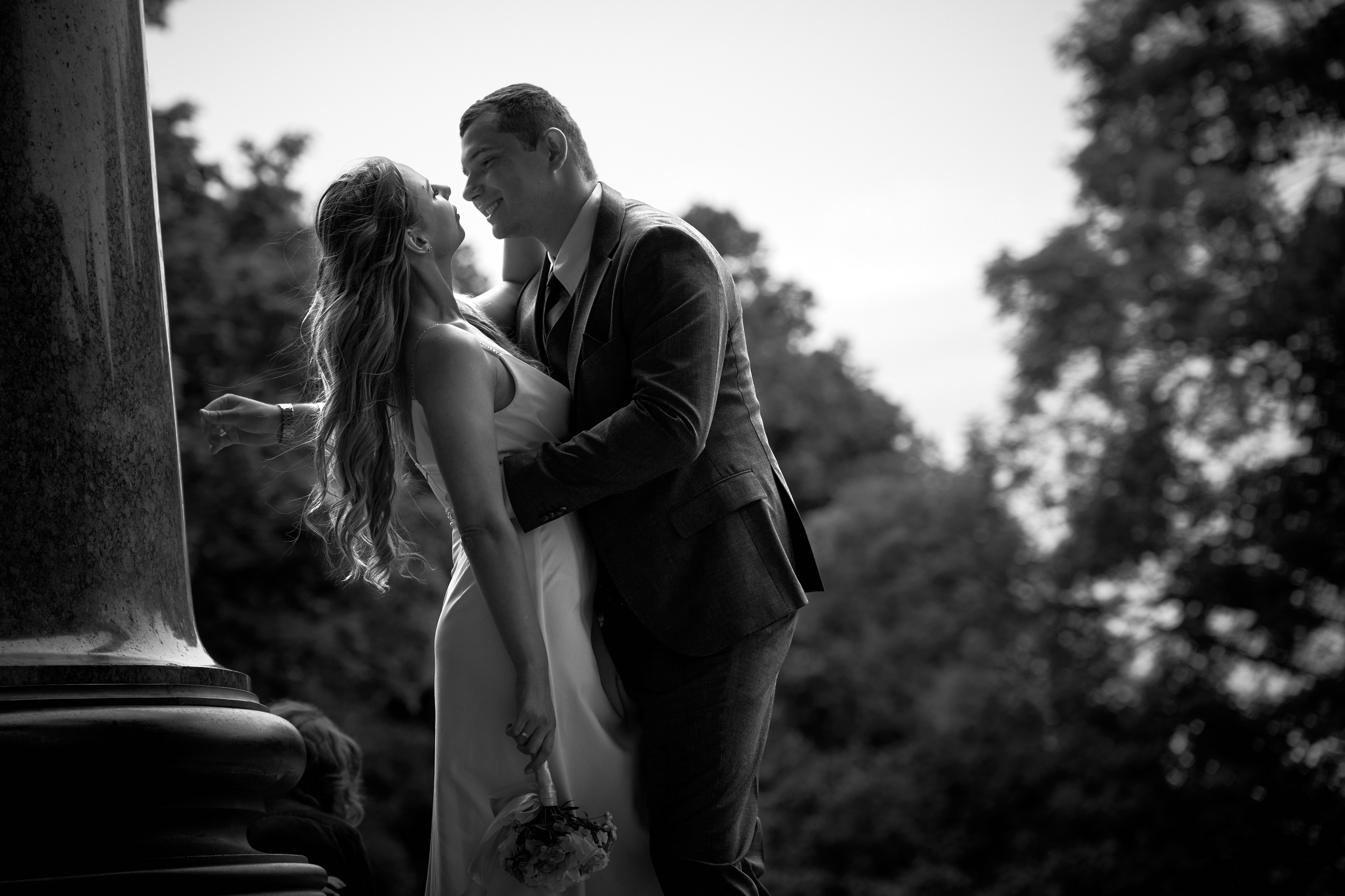 Молодожёны в романтичной позе у колонны, чёрно-белое фото