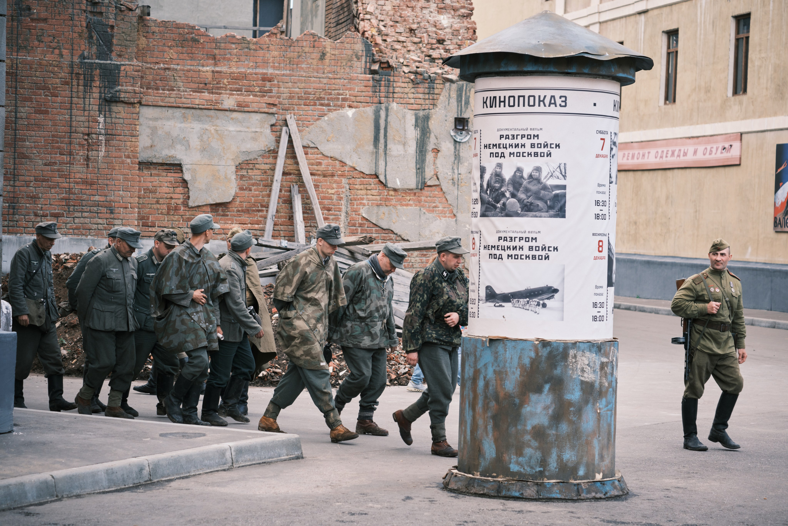 Русские солдаты ведут пленных немцев рядом с вывеской кинопоказ в Москве 1945г