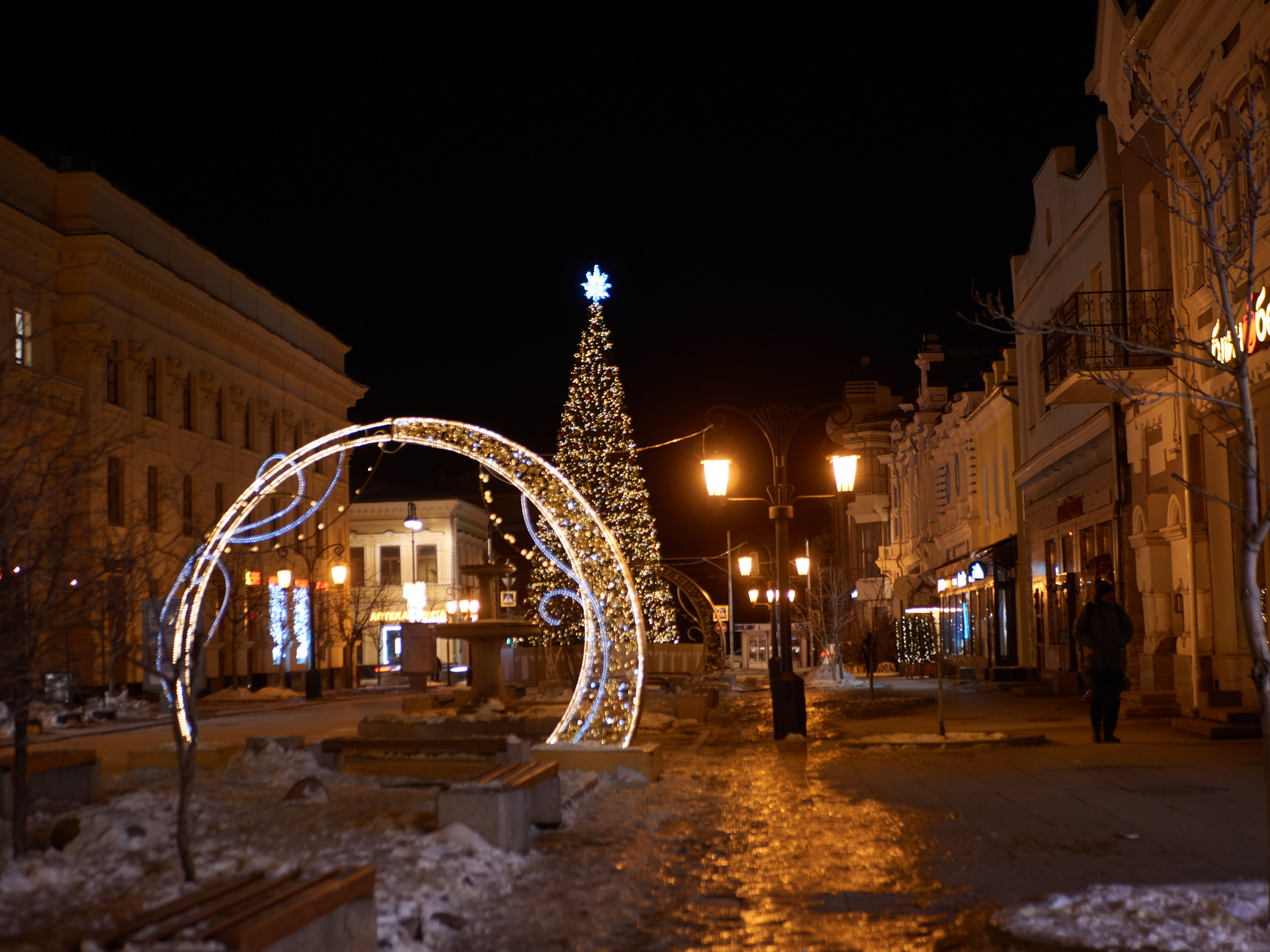 Зимний пейзаж на пешеходной улице Ленинградской с сияющими огнями и нарядной атмосферой.