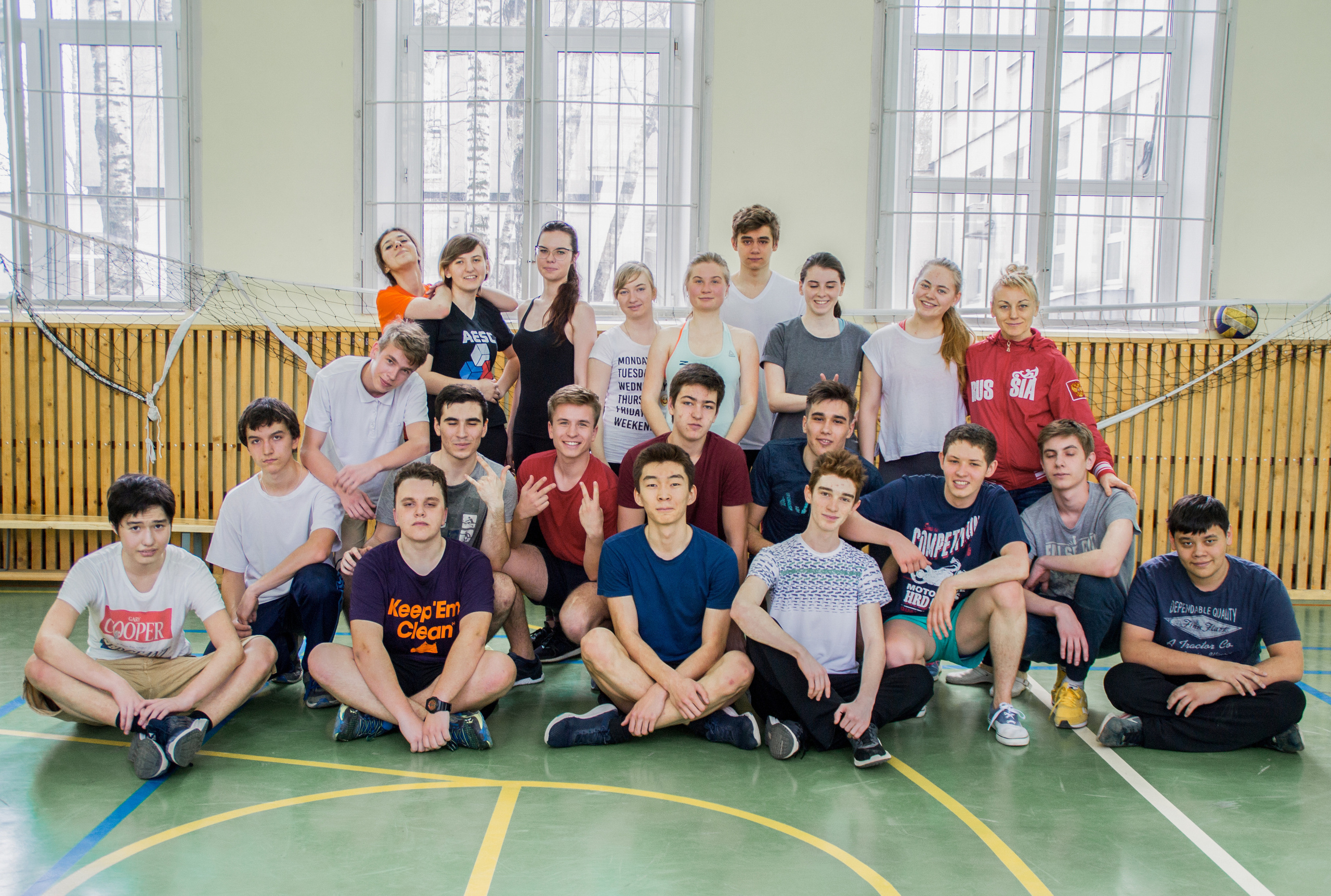 Класс весело позирует в спортивном зале для выпускного альбома